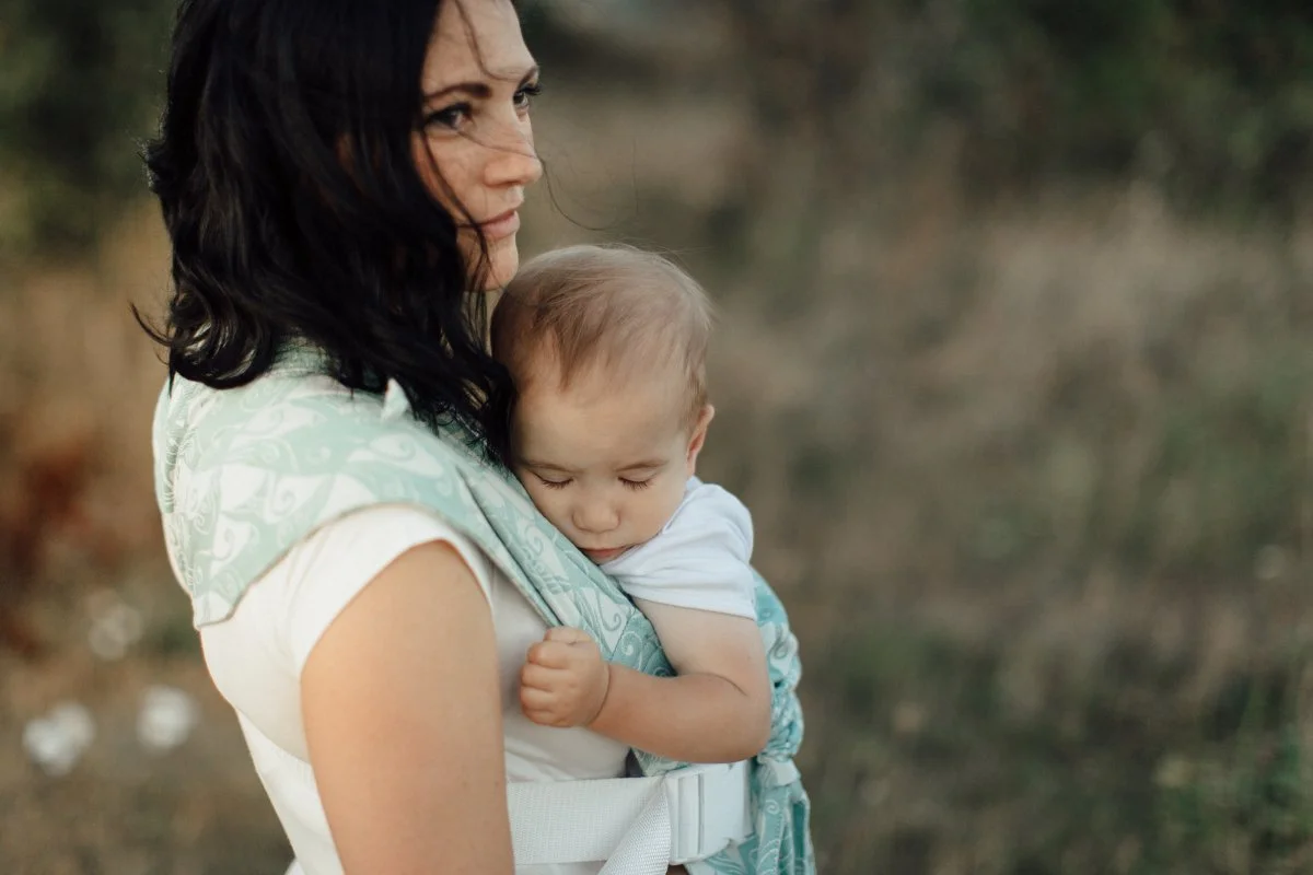 A Nebraska Mom is wearing her baby in a buckle carrier after a lesson on babywearing.