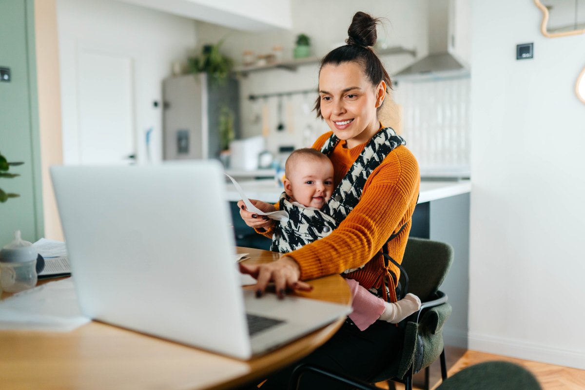 A Nebraska mom is on a virtual call with a baby wearing educator. Her baby is being worn in a structured carrier safely.