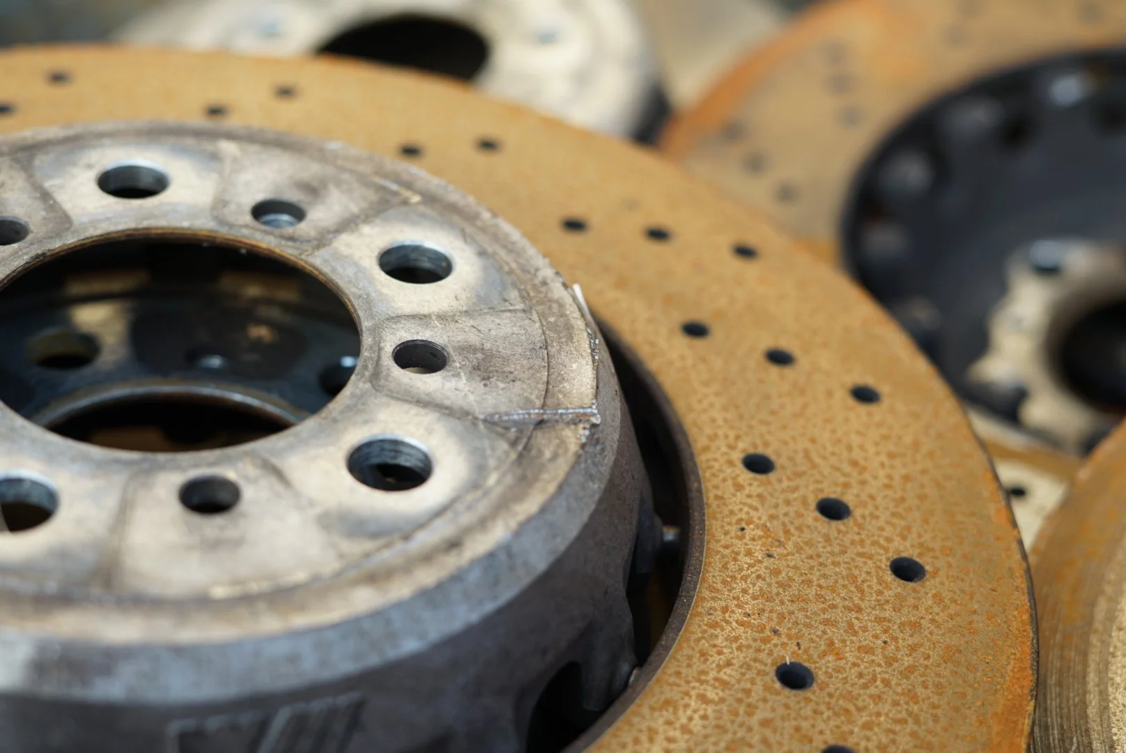 Close-up of rusty and worn brake rotors stacked together.