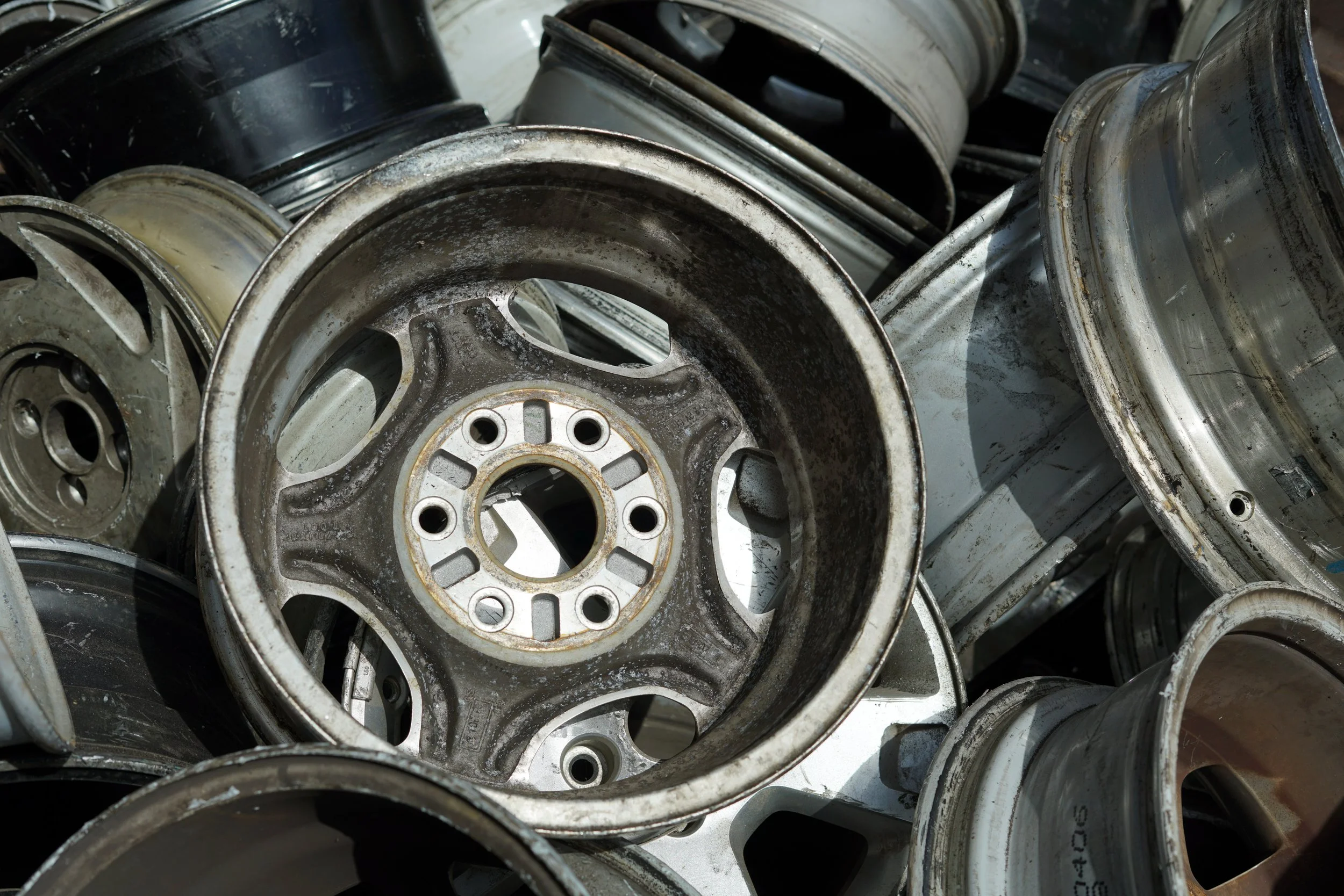 A pile of recycled, aluminum rims.