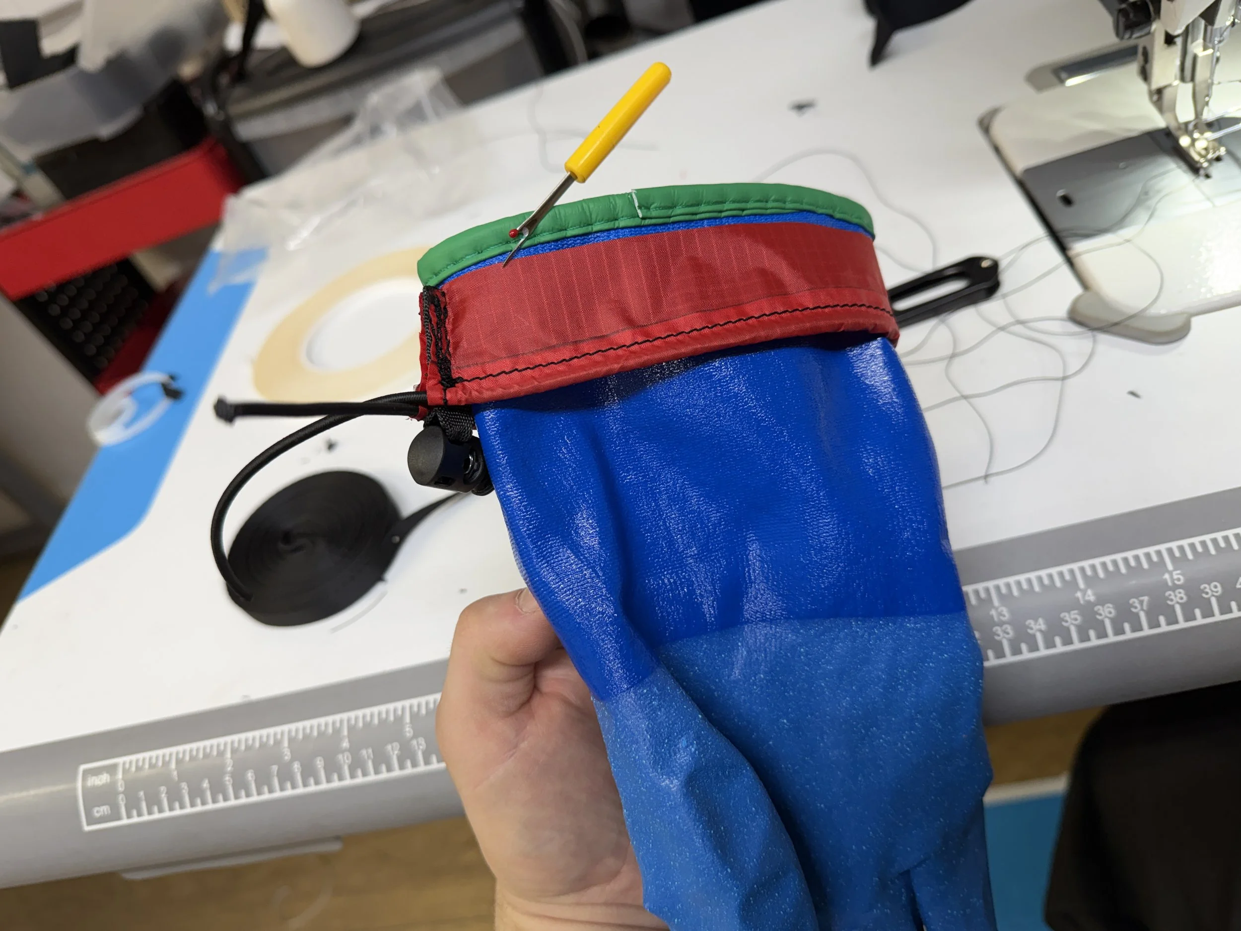 Keep inside out and slide down glove. Unpick green binding from glove. 