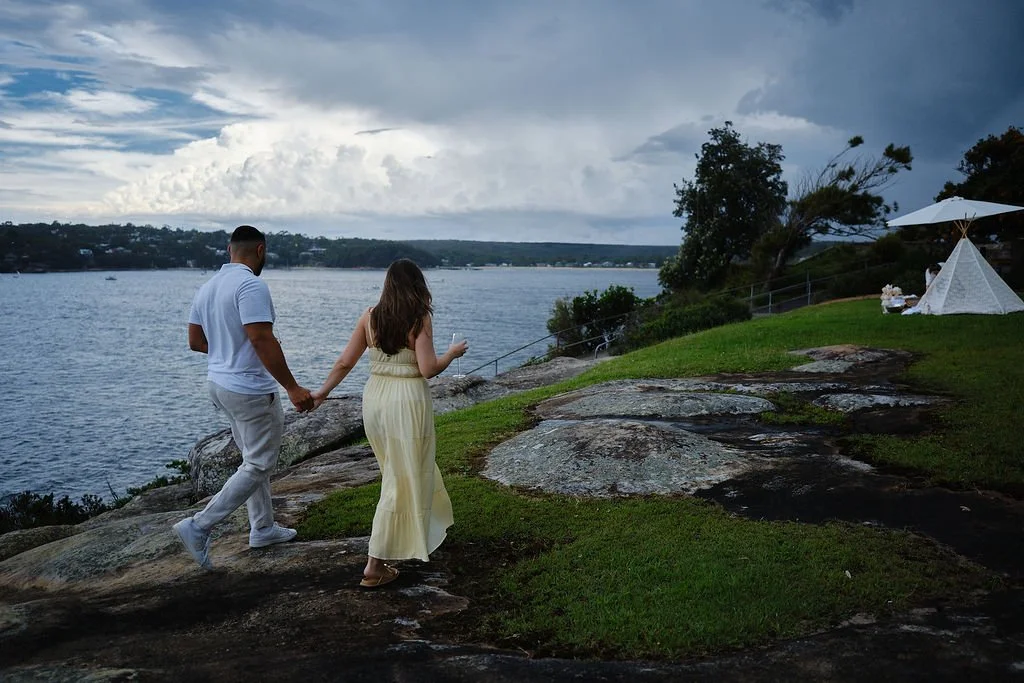 Couple walking at Cronulla with coastal views during engagement