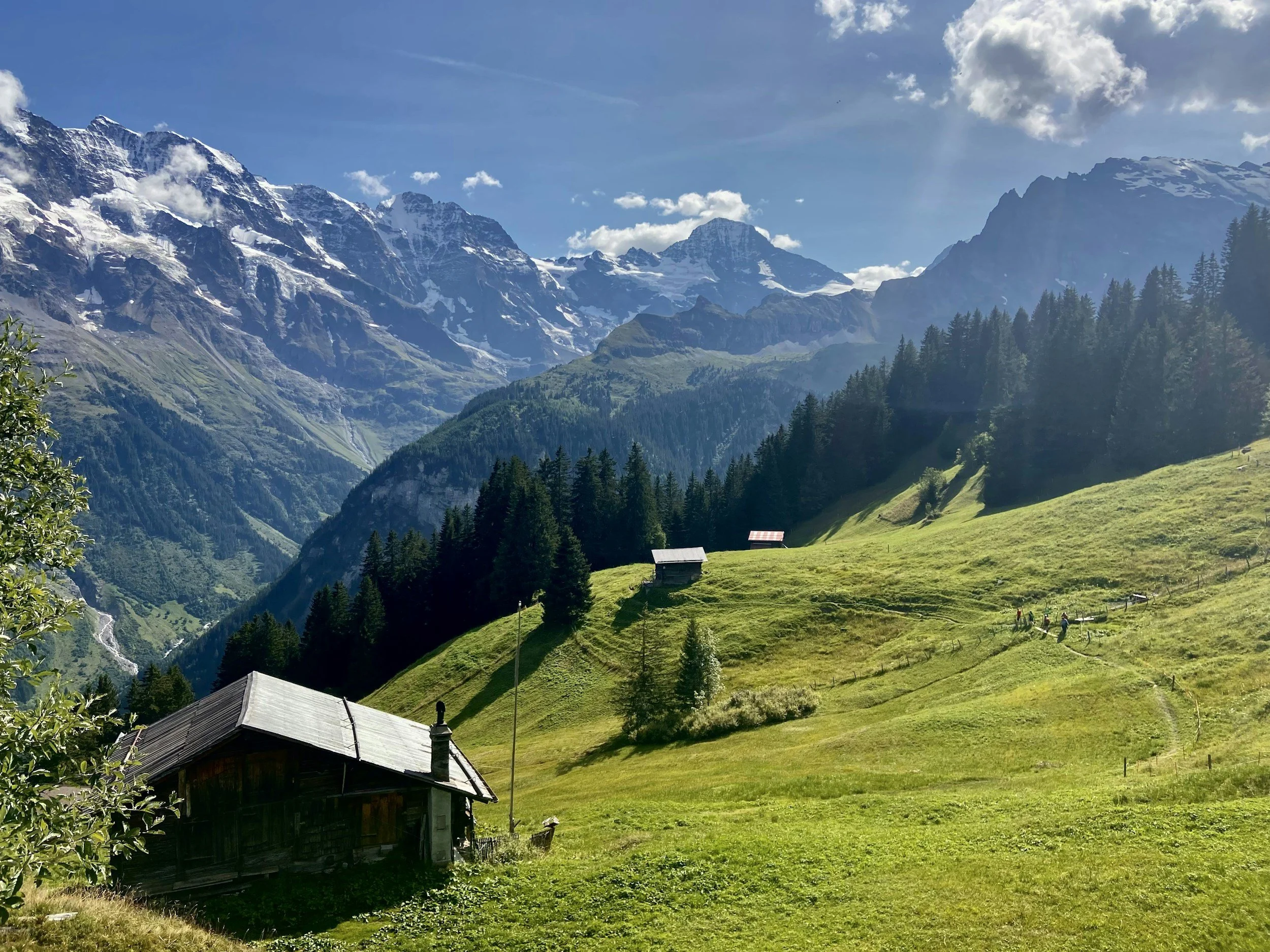 “French Alps summer sunlight over Praz-sur-Arly mountains — off-grid yoga, hiking and community retreat setting
