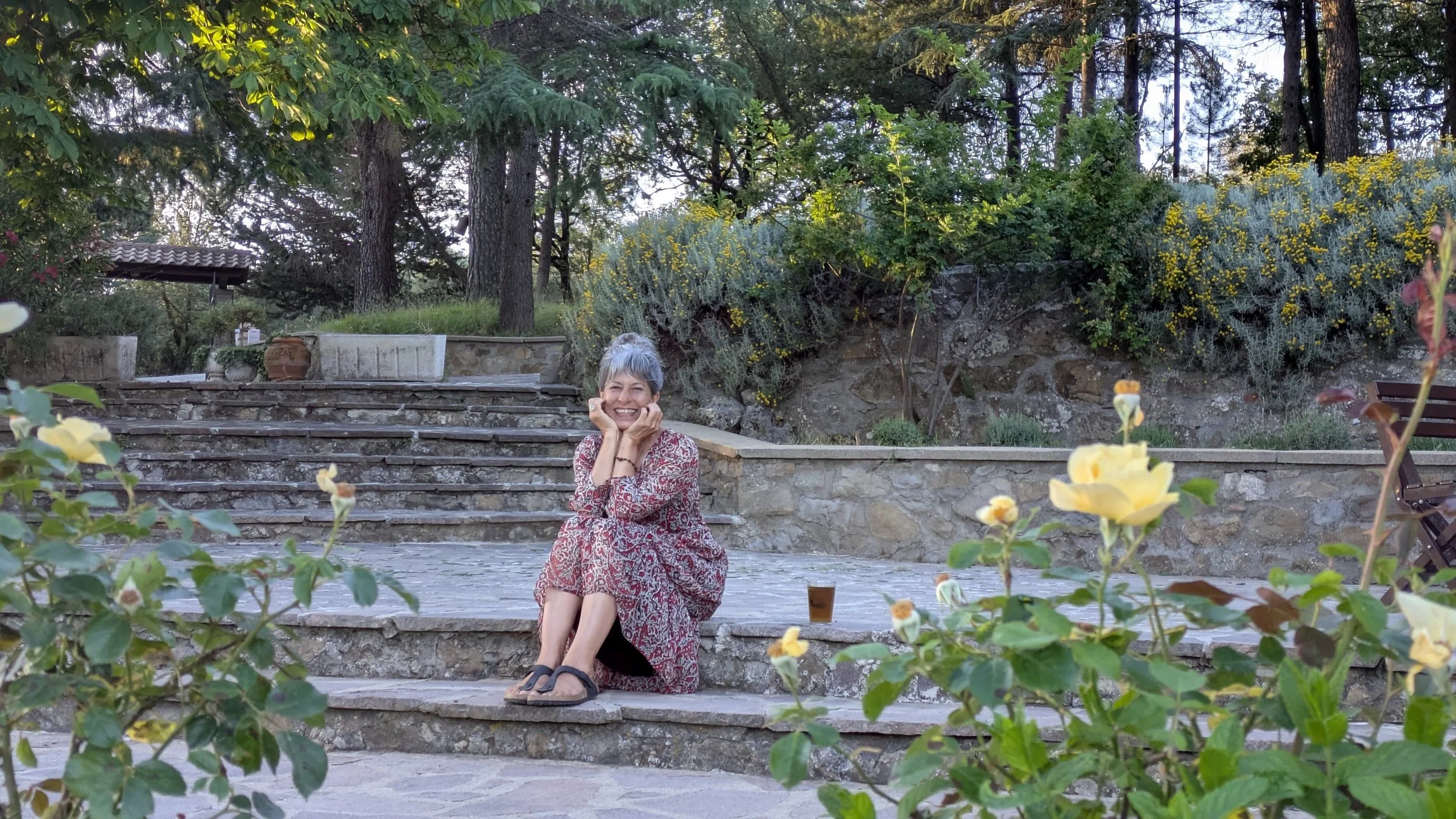 soraya allison sitting on stone steps, wearing flowing dress