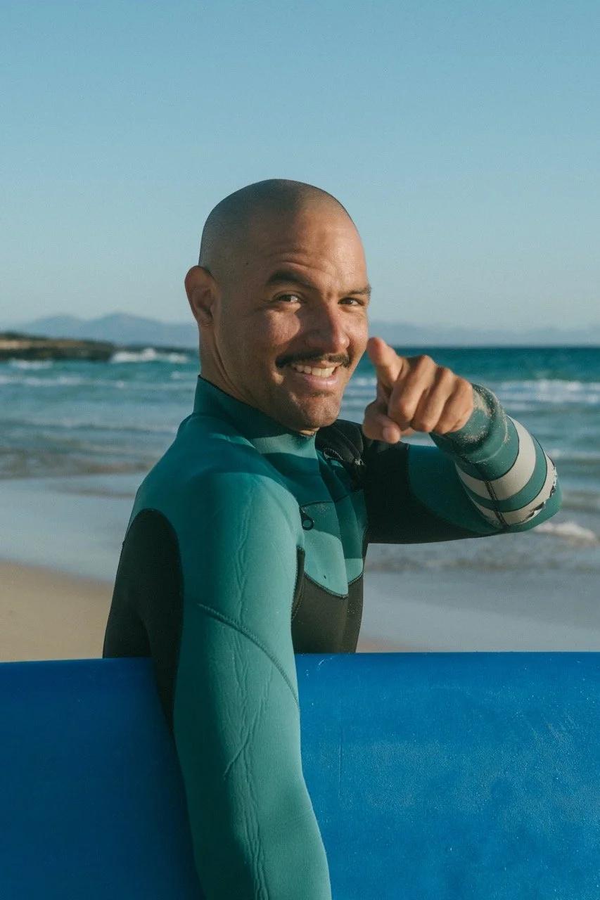 Surf instructor from Willing to surf Fuerteventura with a surfboard under the arm