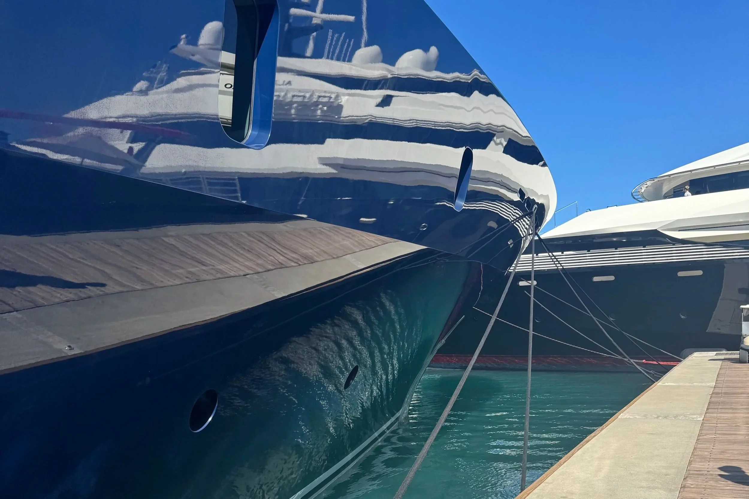 View of a boat's bow with navigation equipment and a calm ocean in the background.