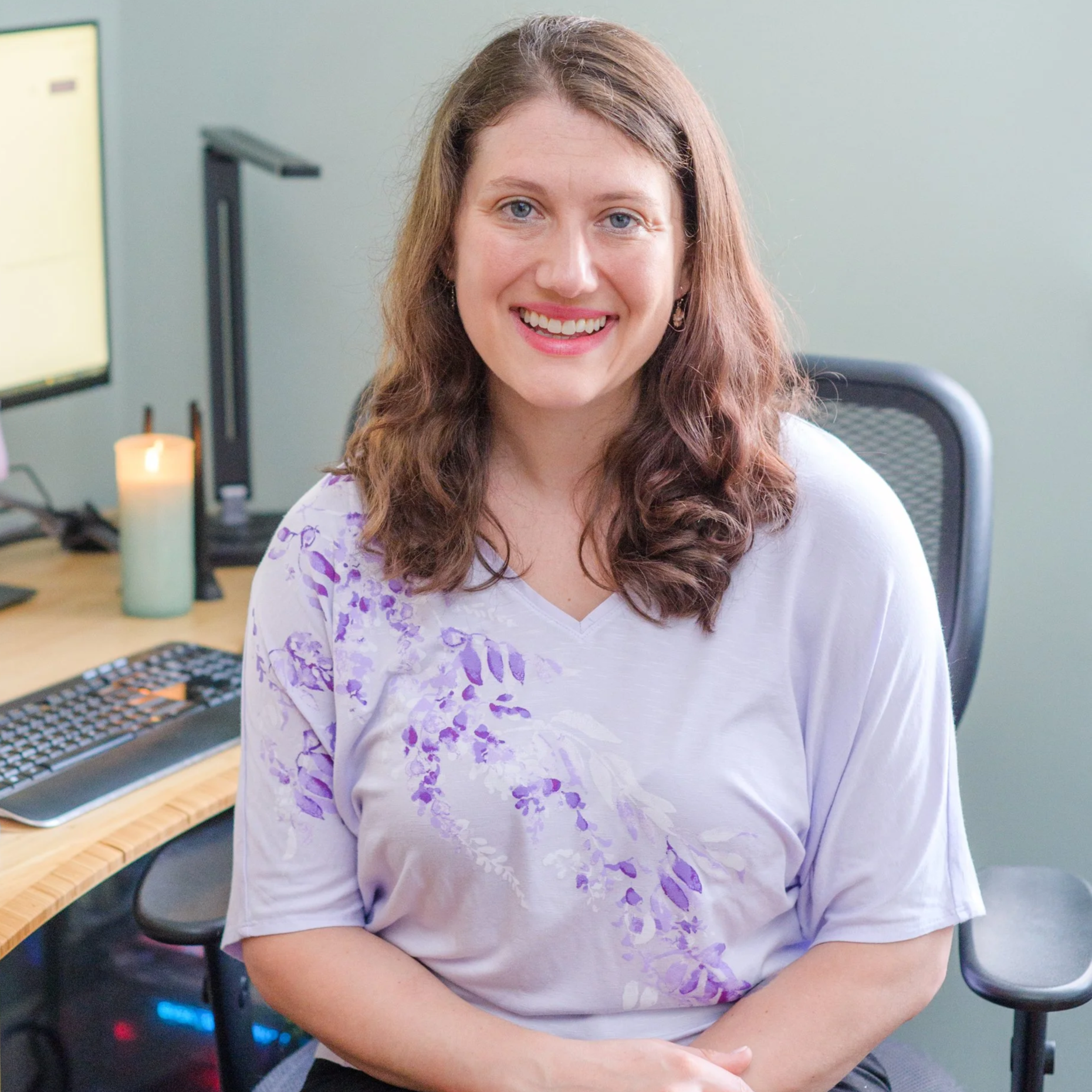 Katie LaCelle sitting at her computer, smiling and open