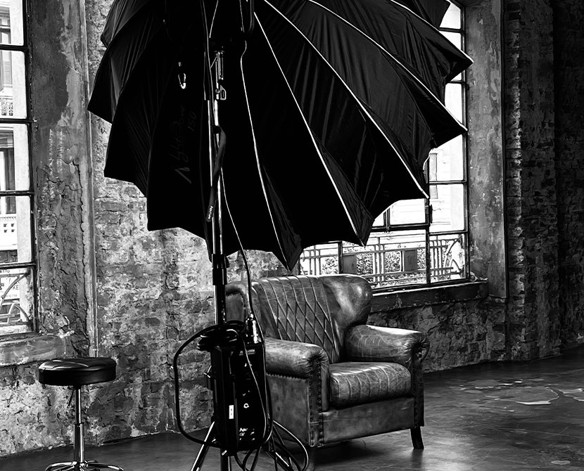 Studio setup with lighting equipment, vintage armchair, and textured walls.