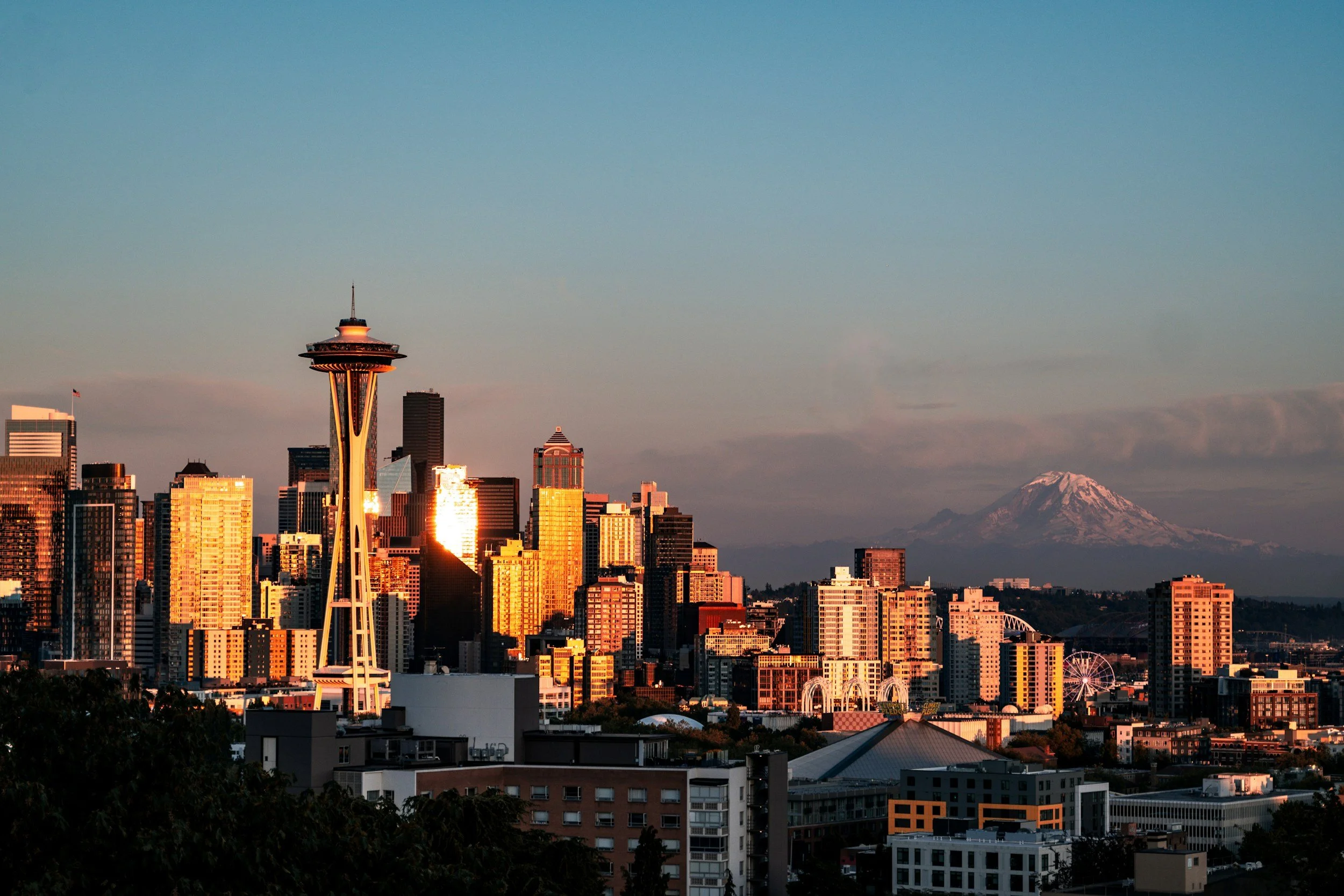 Seattle skyline with the Space Needle and Mount Rainier at sunset, location of the Henley Live leadership conference.