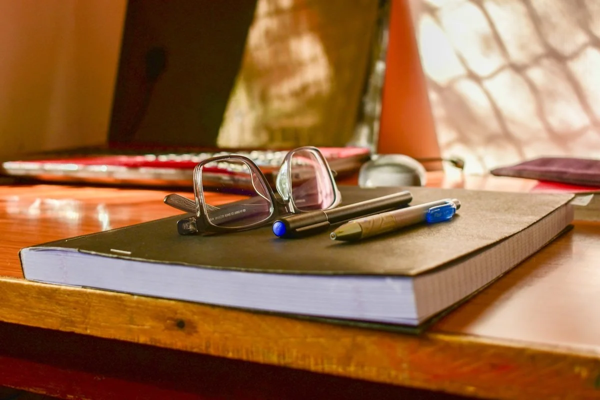 Notebook and reading glasses left on a desk after a leadership retreat