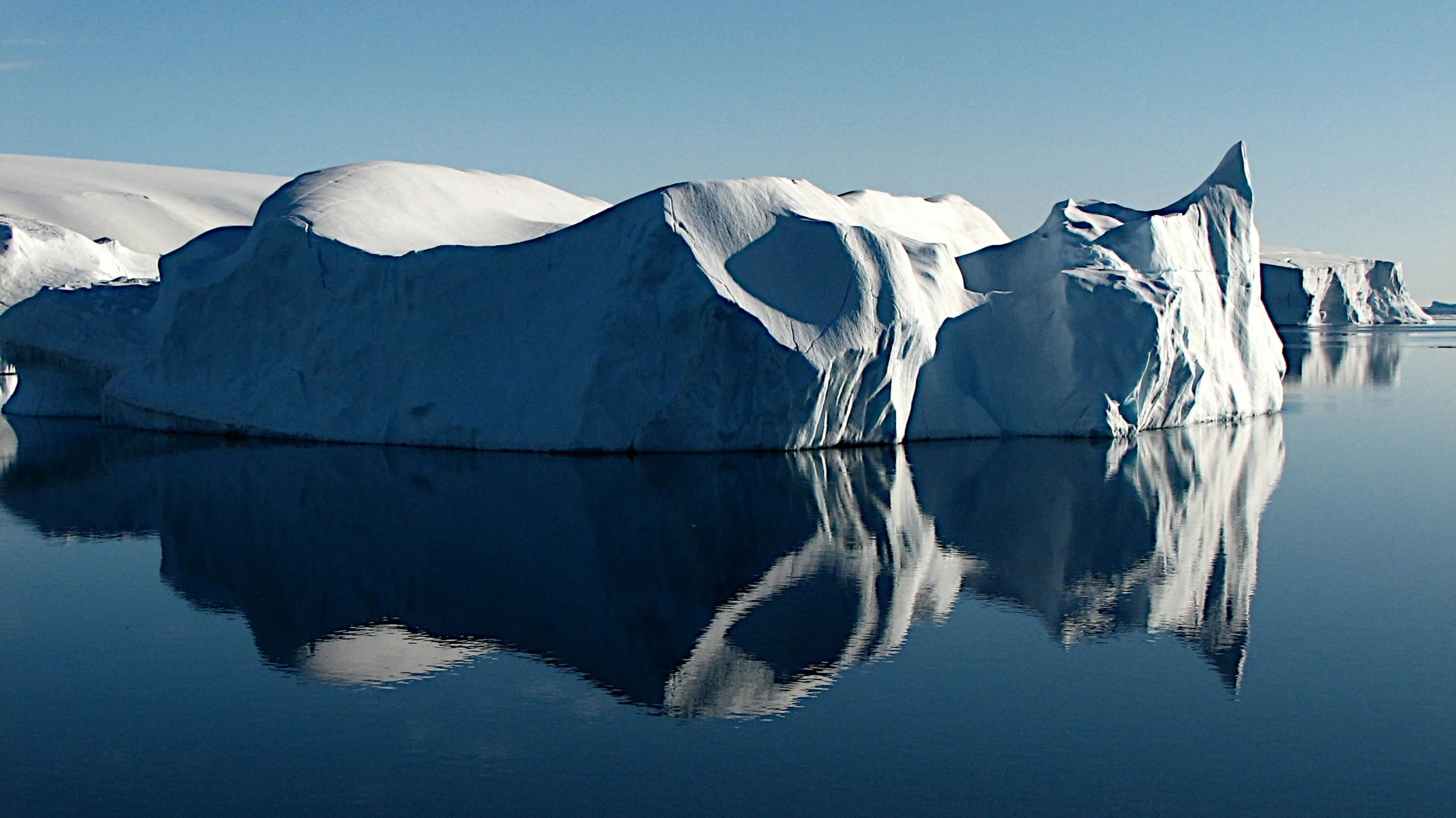 Iceberg floating in calm dark water, with only the visible tip above the surface, symbolizing the hidden layers of organizational culture.