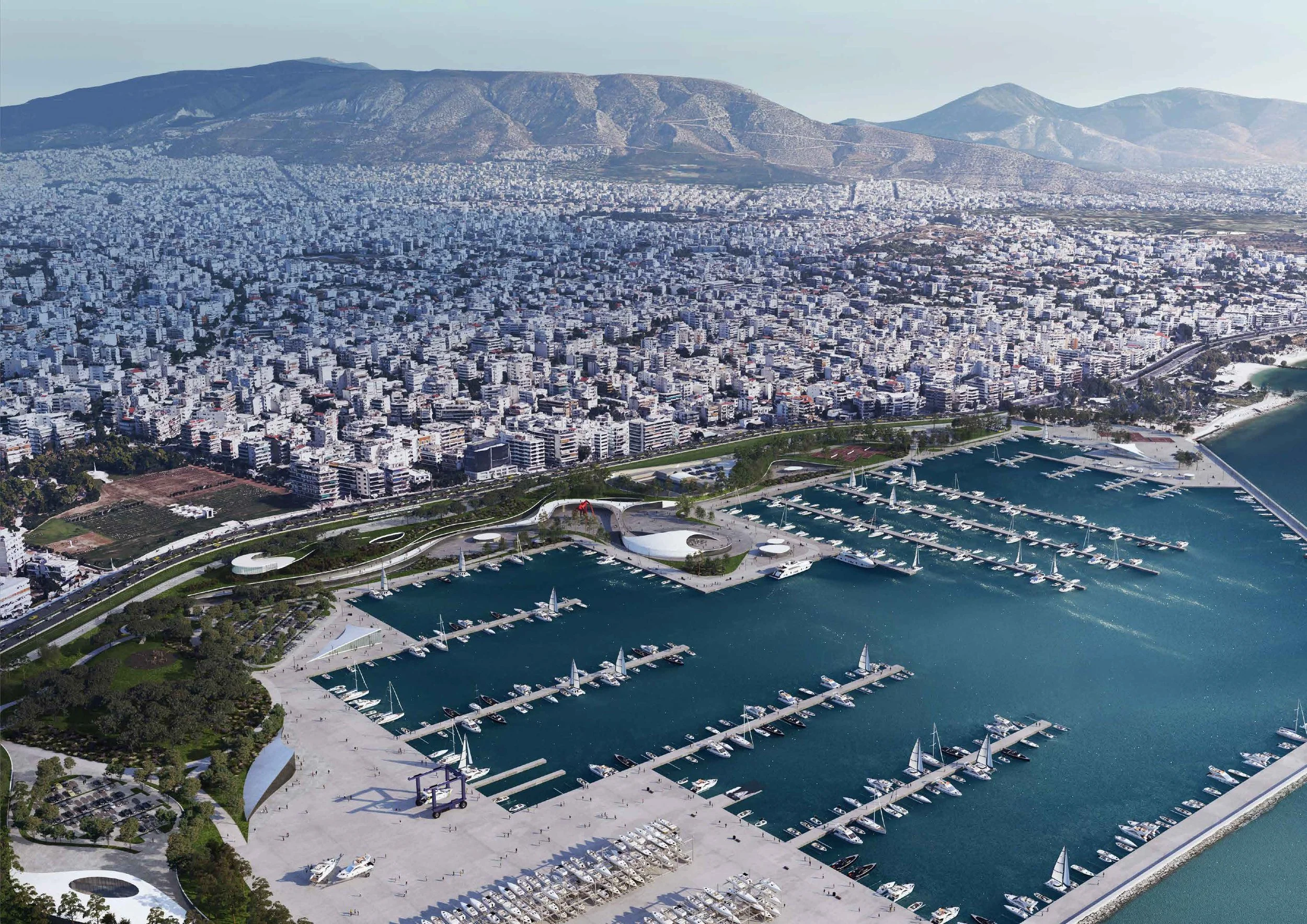 Aerial view of a large marina filled with sailboats and yachts, adjacent to a sprawling city with numerous white buildings, with mountains in the background.