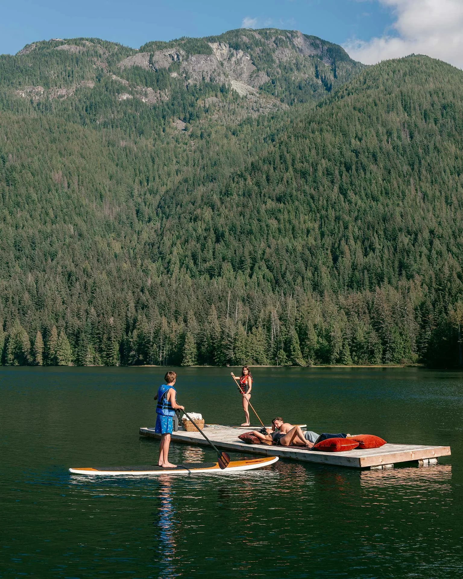 Guests enjoying a variety of watersports (including stand up paddle boarding at Fawn Bluff private lodge, a luxury West Coast retreat.