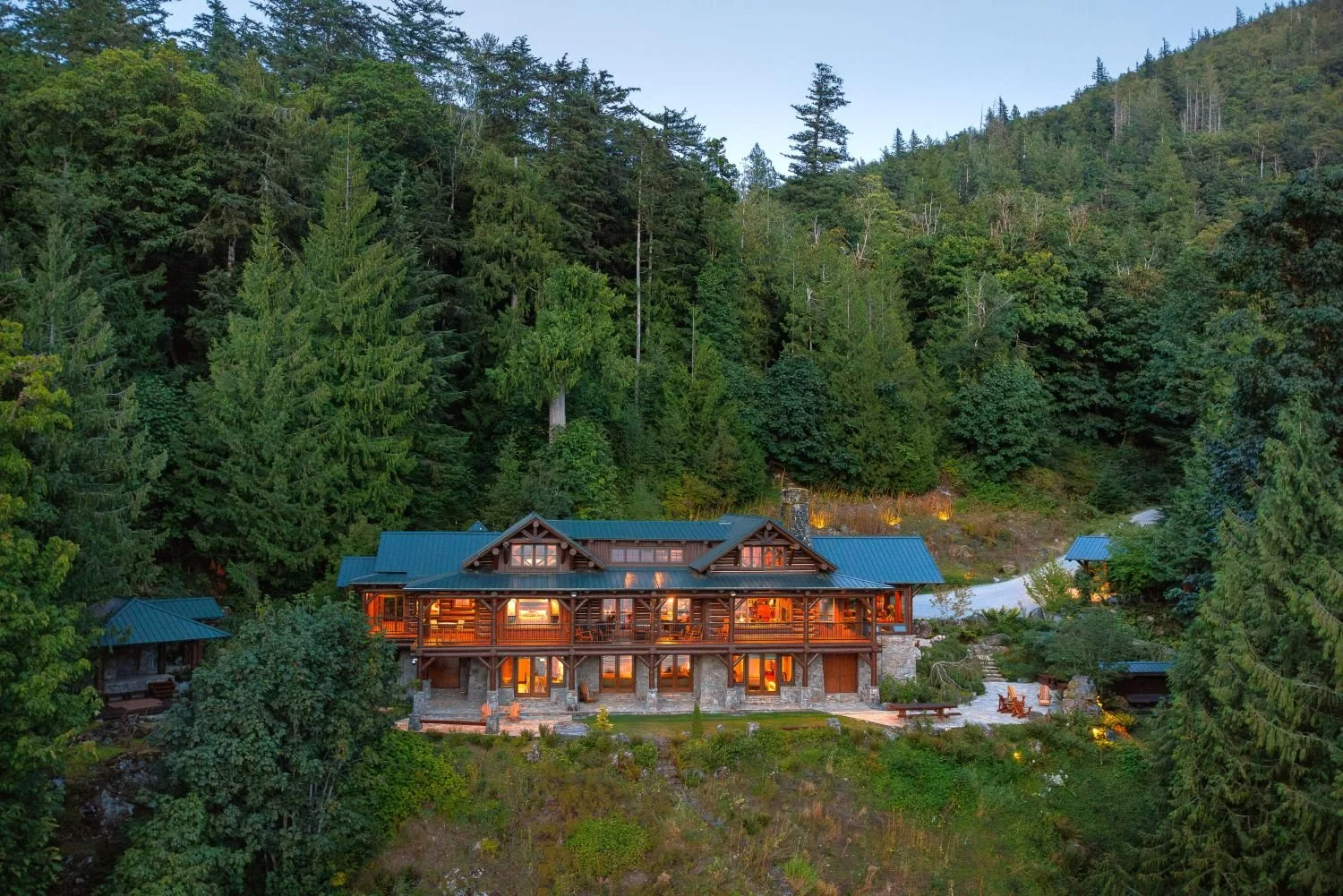 The main house at Fawn Bluff Private Lodge glowing warmly at dusk, showcasing the cozy, exclusive wilderness estate sanctuary.
