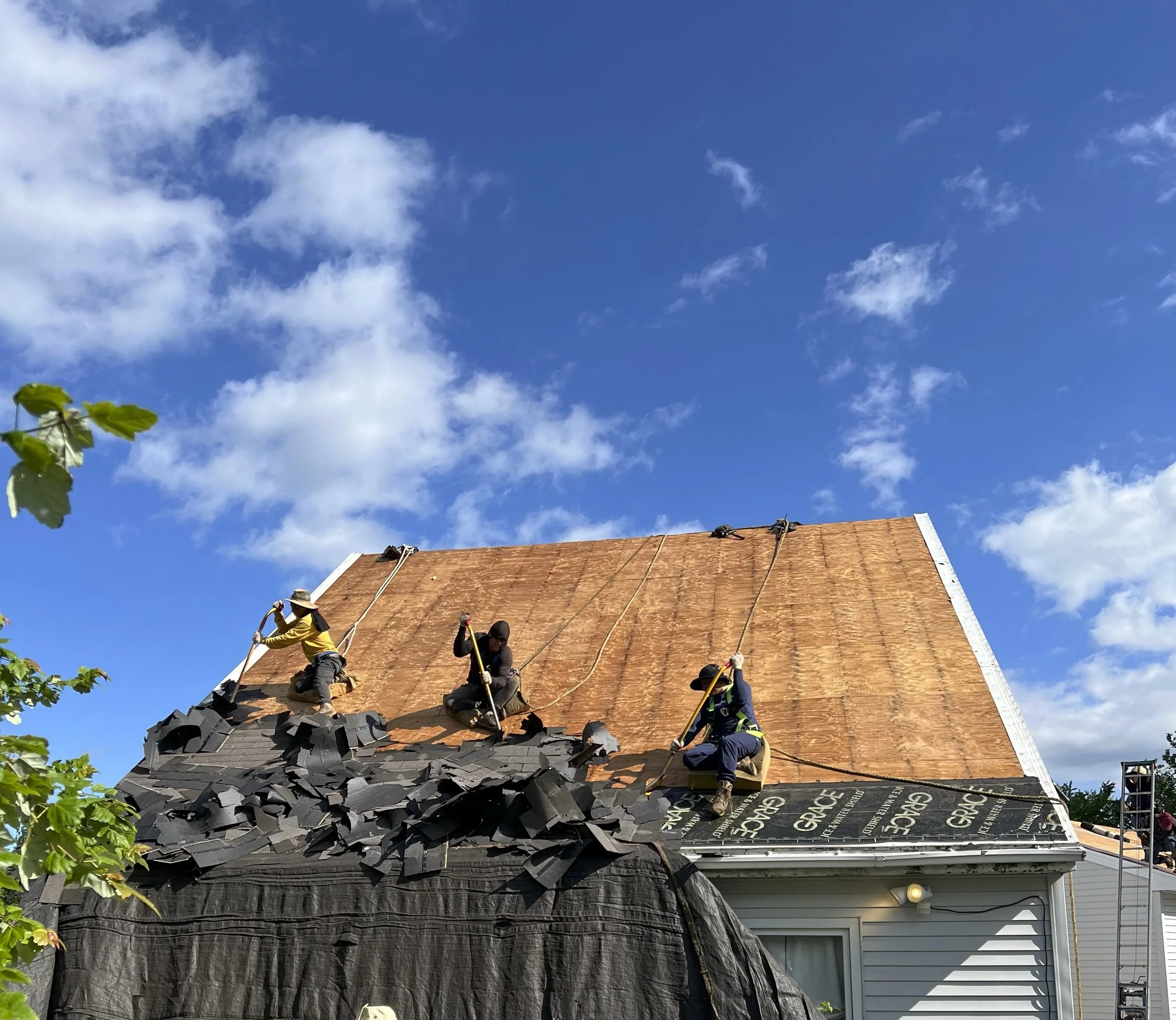TopDog Roofing crew removing an existing asphalt roof on a Maine home