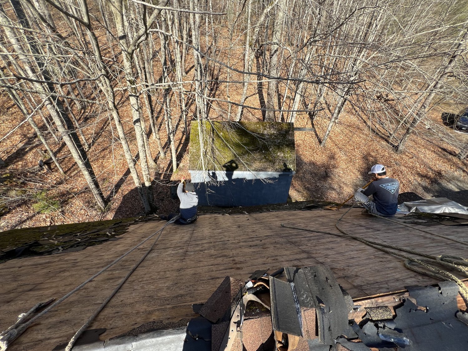TopDog Roofing stripping old shingles from a shop roof in Waterboro Maine