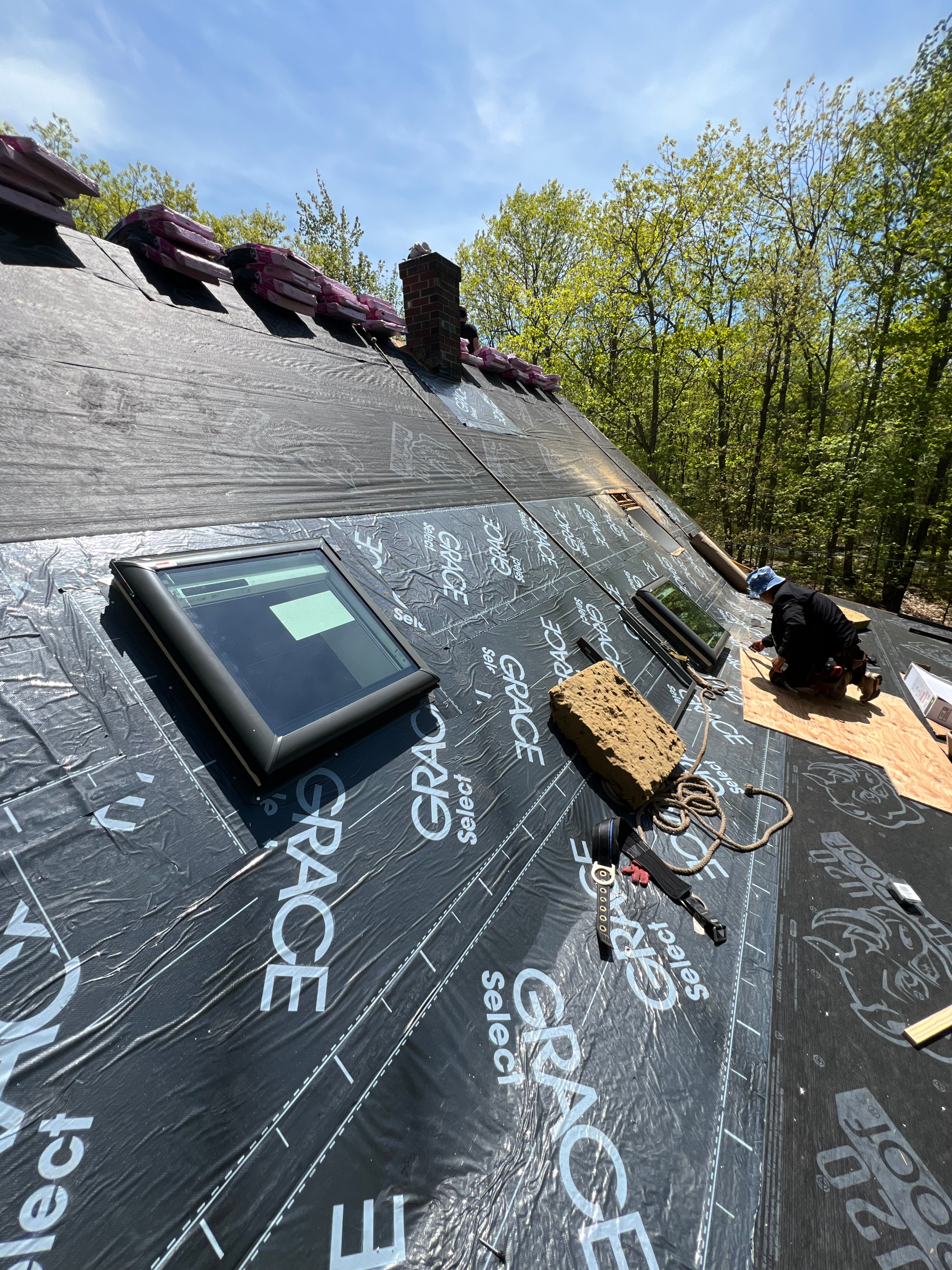 TopDog Roofing installing synthetic underlayment around skylights during a Southern Maine roof replacement