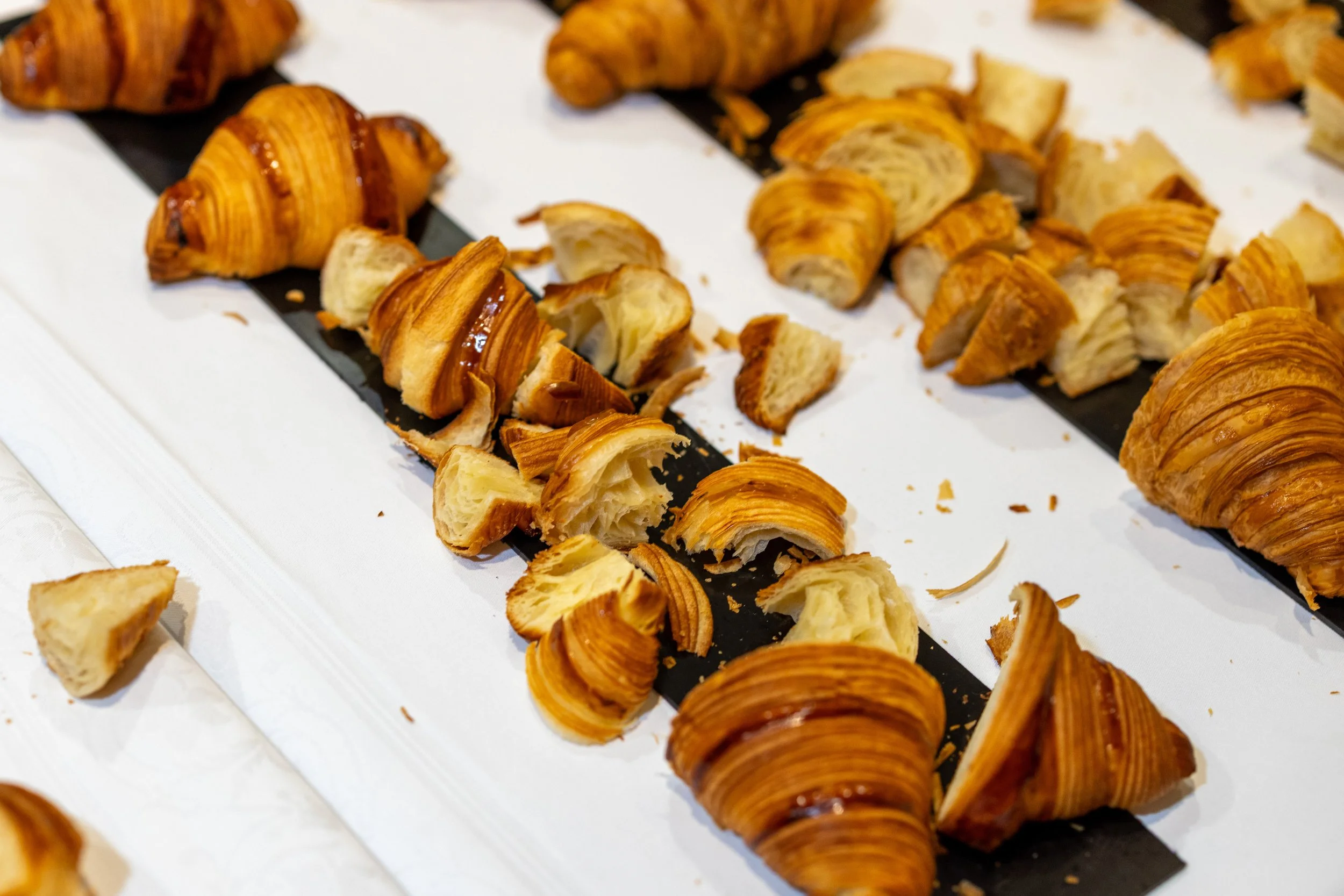 Broken croissants on a black and white surface.