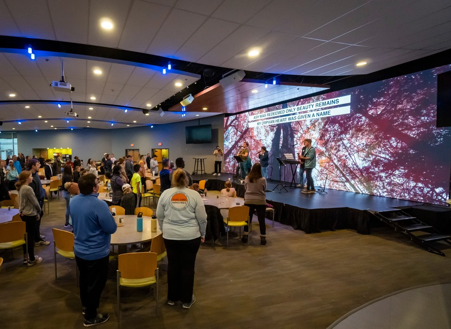 Worship service with lyrics on a large LED wall behind the band
