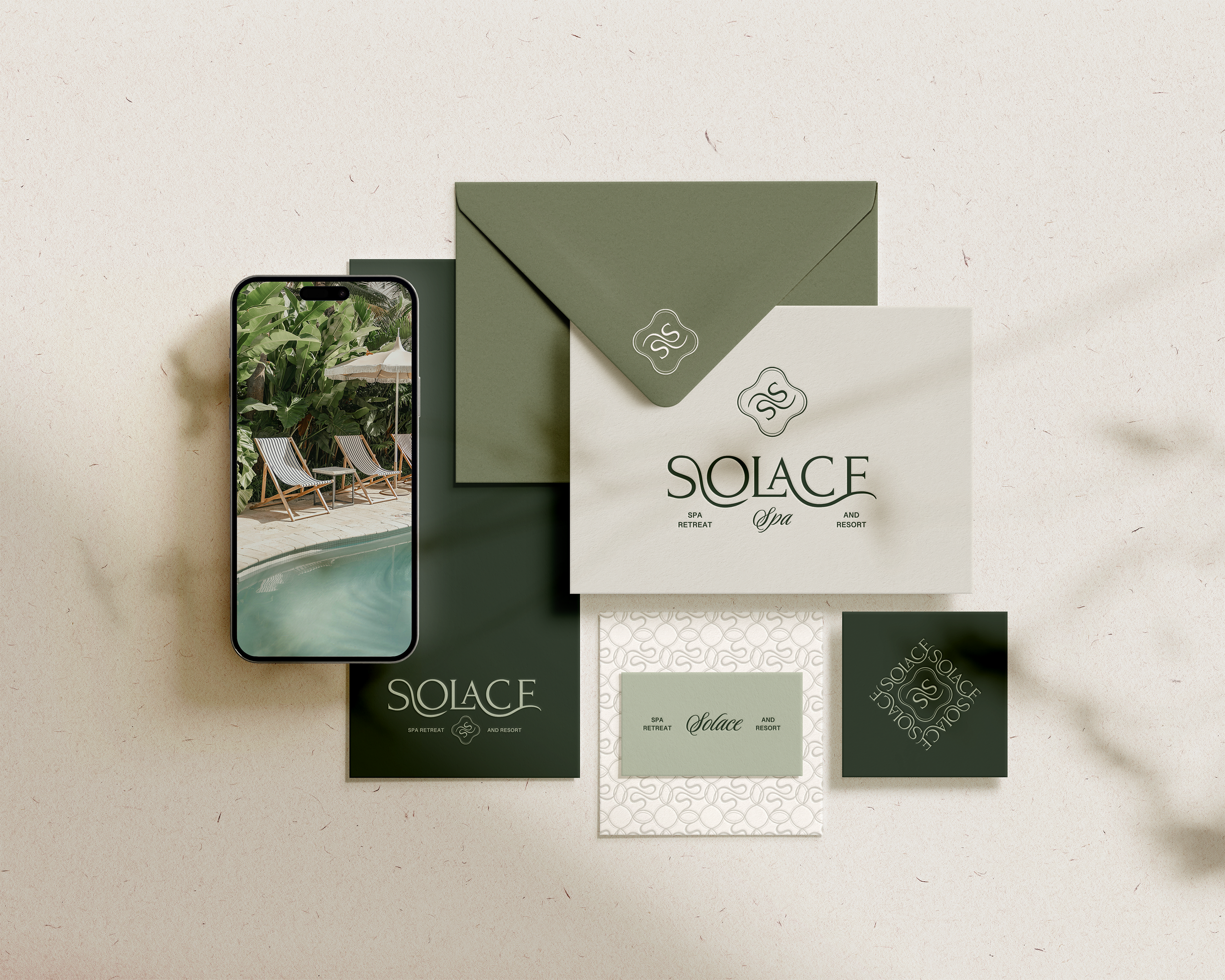 Mockup of a spa resort brand design featuring a smartphone displaying a poolside scene, green and cream stationery items with "Solace Spa Retreat and Resort" branding, including an envelope, invitation card, and business card.