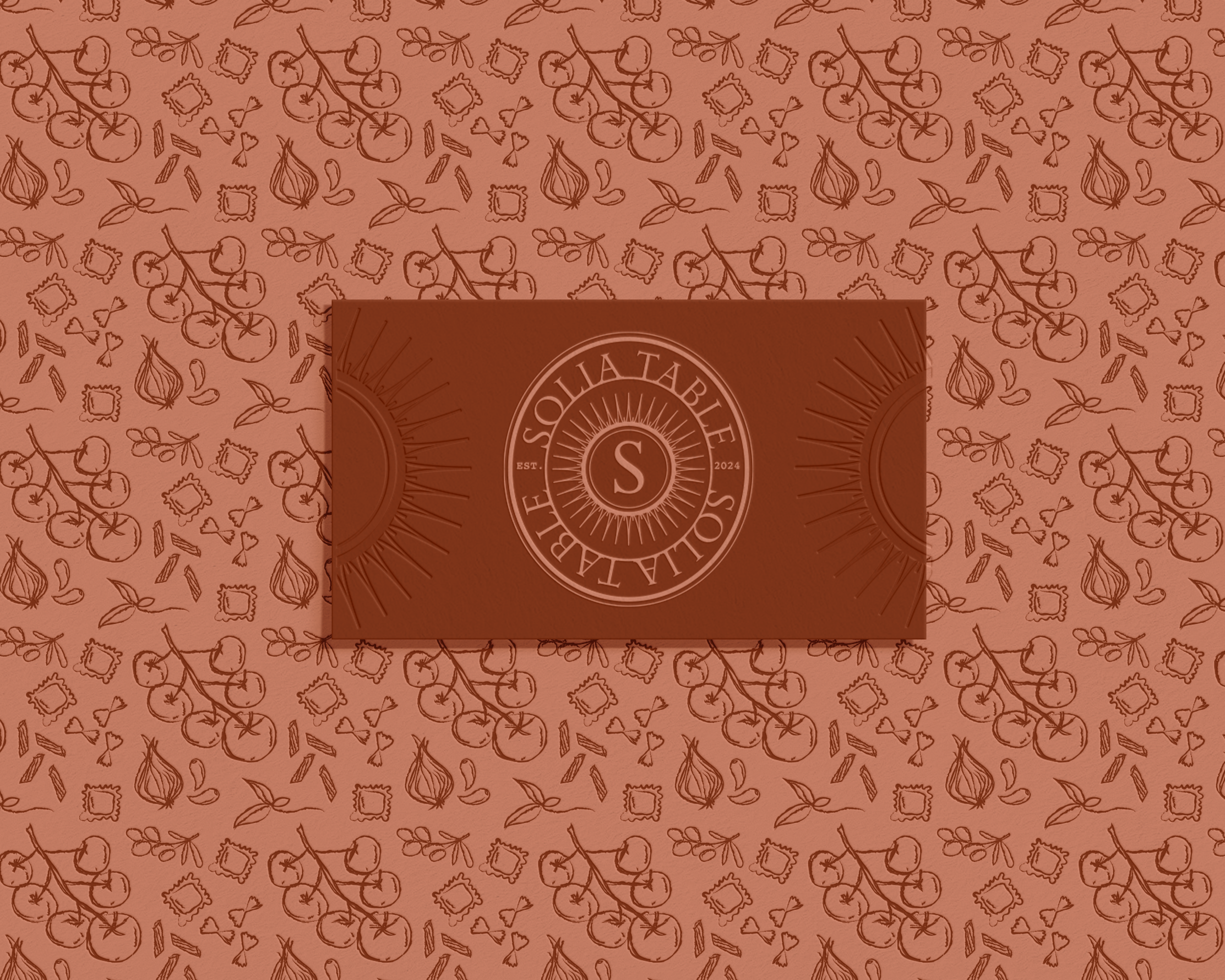 Decorative pattern with tomatoes, onions, herbs, and pasta; centered embossed logo with letter 'S' and "SOLIA TABLE EST. 2024."