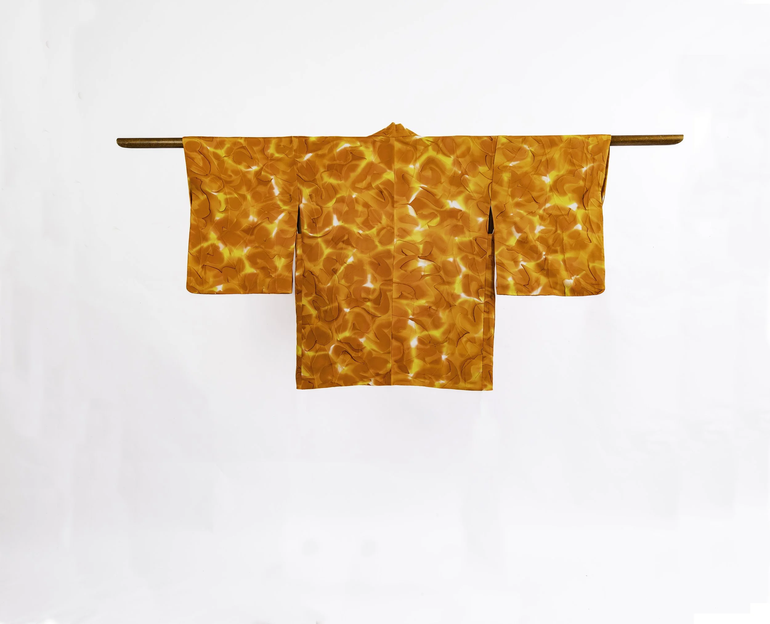 back of Short orange vintage kimono against a white wall