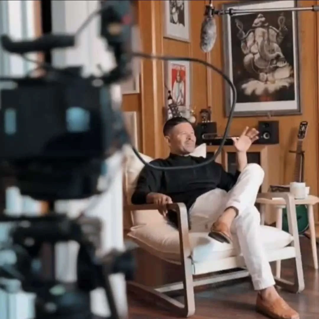 Camera equipment including a professional film camera, a monitor displaying a photo of a woman in nature, a control pen, and a video recorder on a black surface.