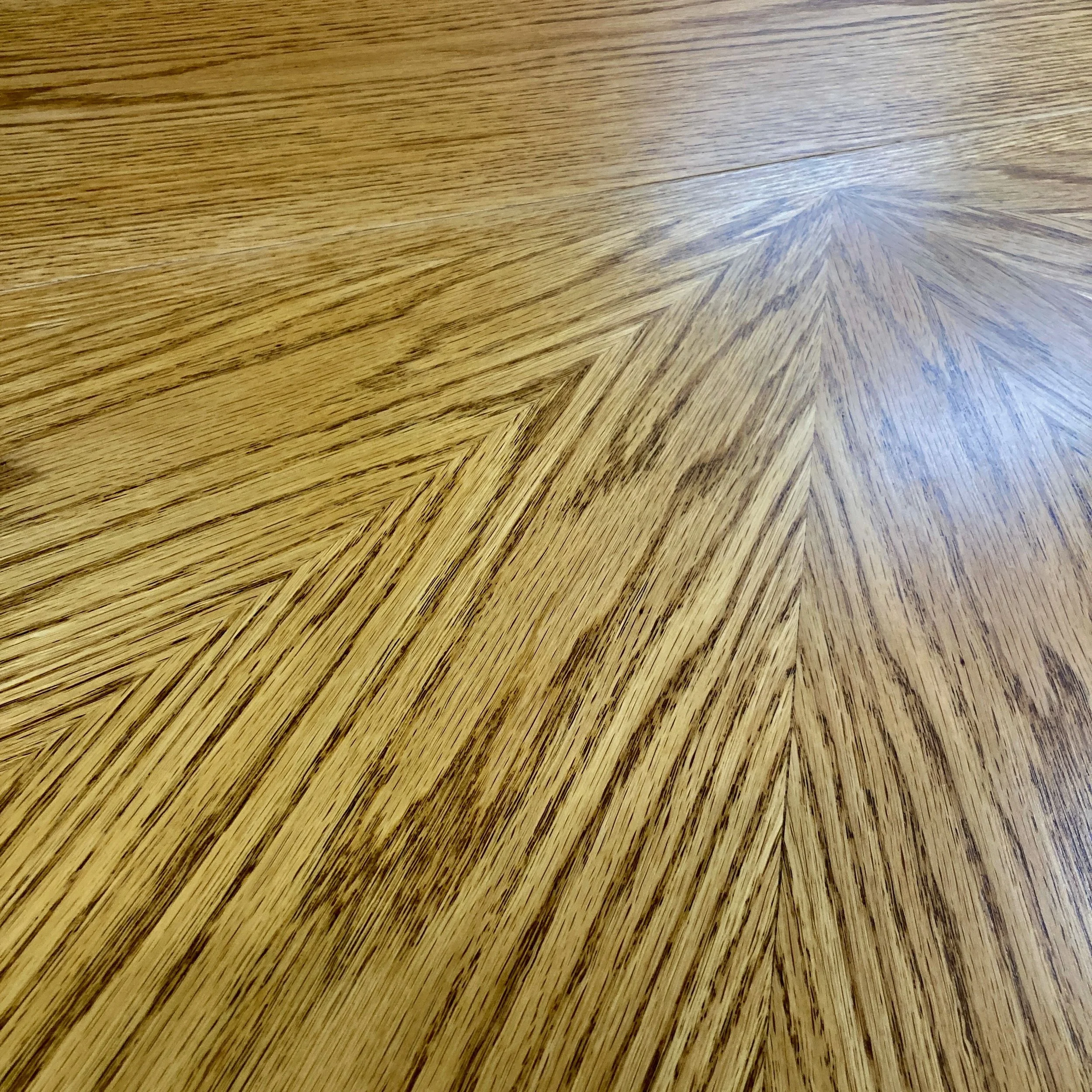Close-up of wooden table surface with a star pattern design in the center.