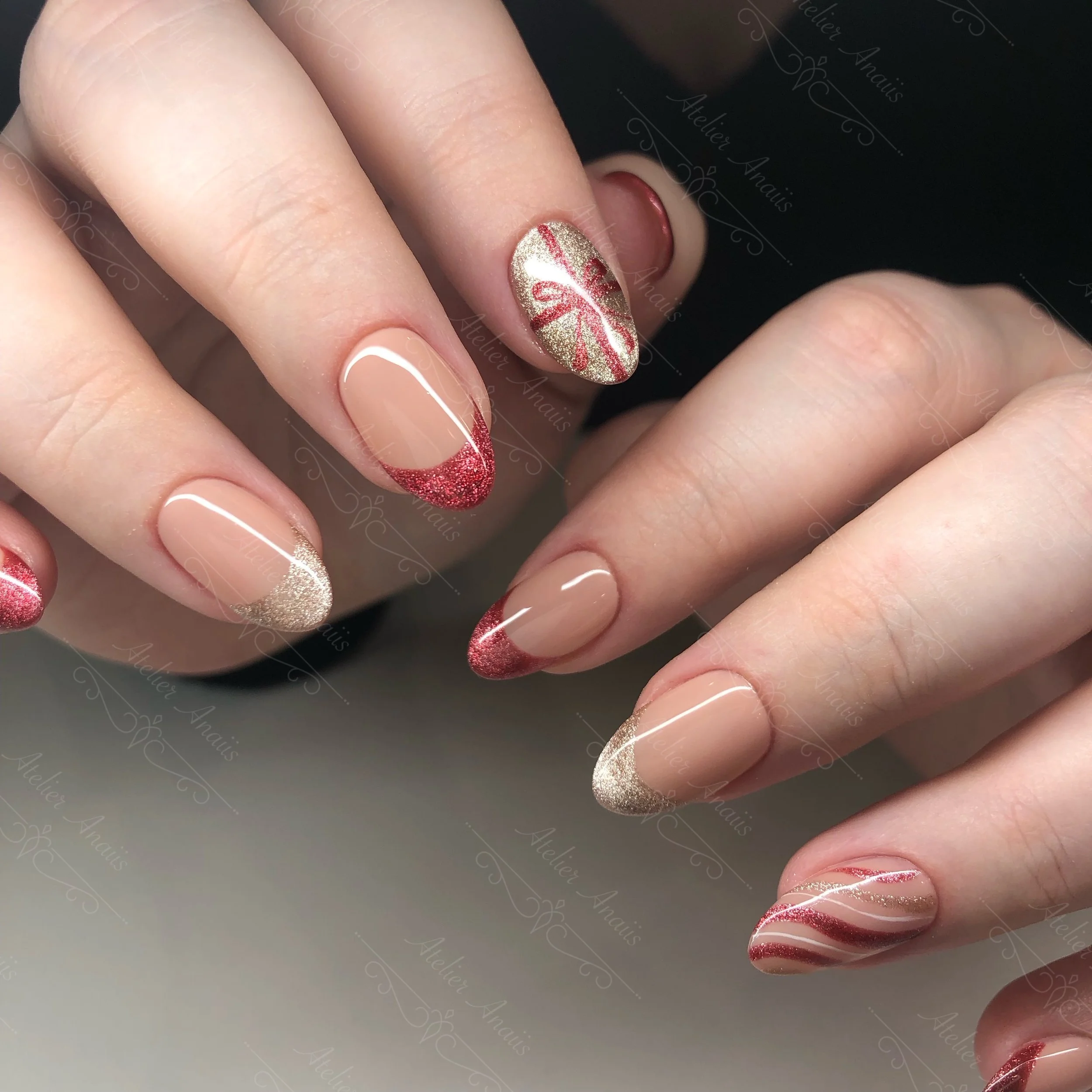 Medium nails featuring red bows and glitter red and champagne French tip nail art on glossy nude base for Christmas.
