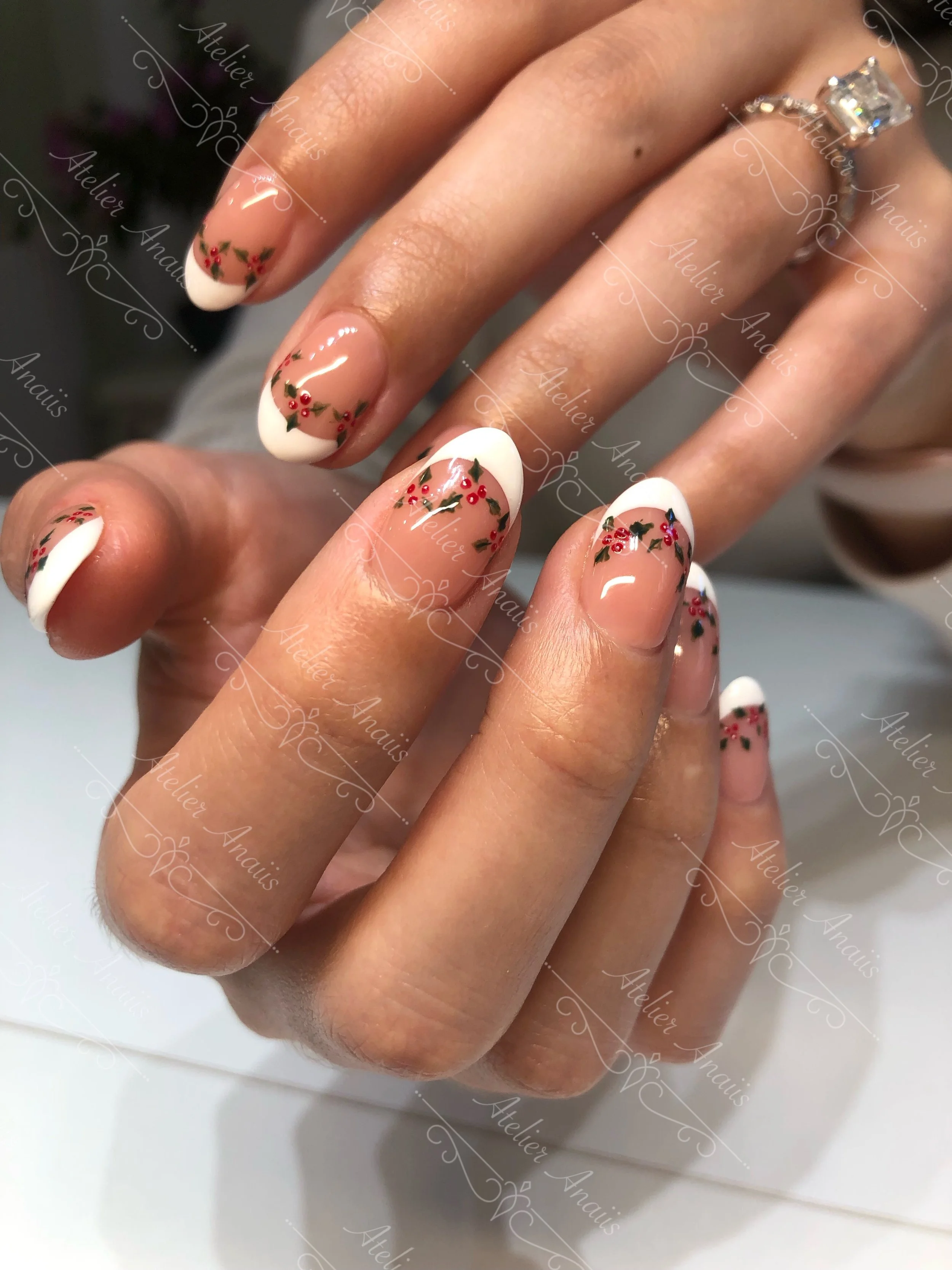 Medium nails featuring hand drawn holly trees and white French tip nail art on brown nude base.