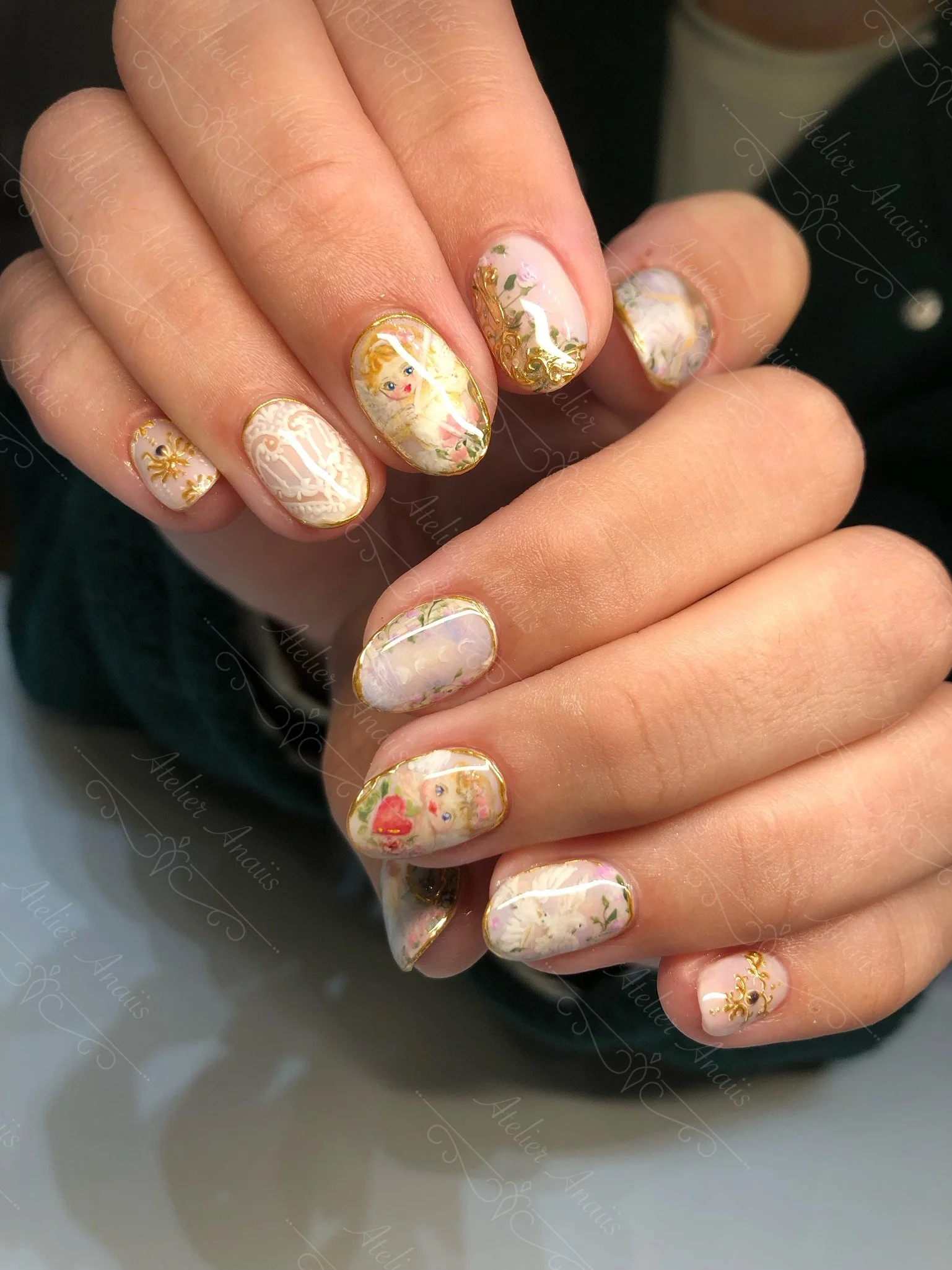 Hands with medium nails featuring hand drawn impressionist nail art inspired by cupids in white and pink. 