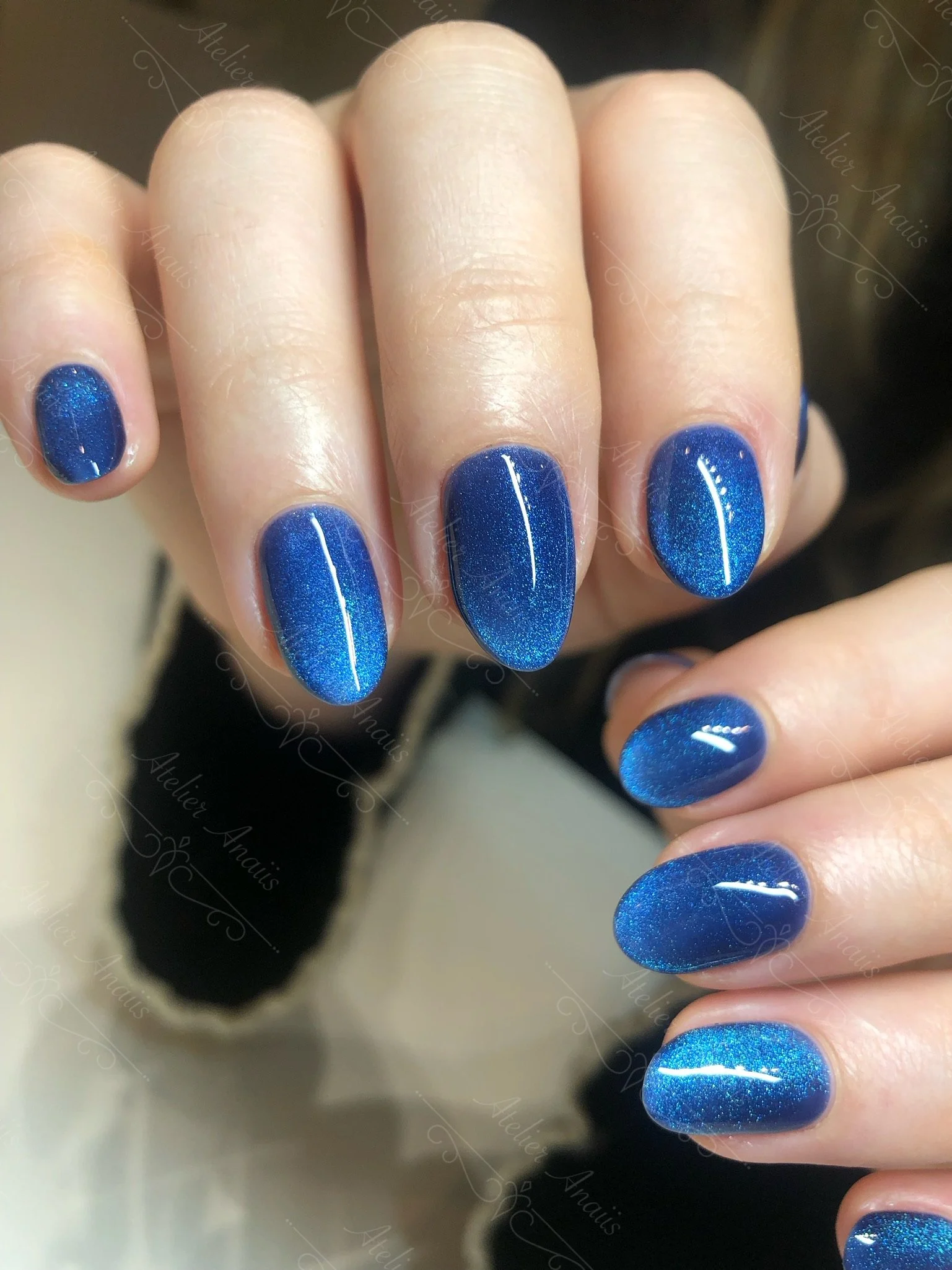 Medium nails featuring deep blue cat-eye velvet gel polish. 