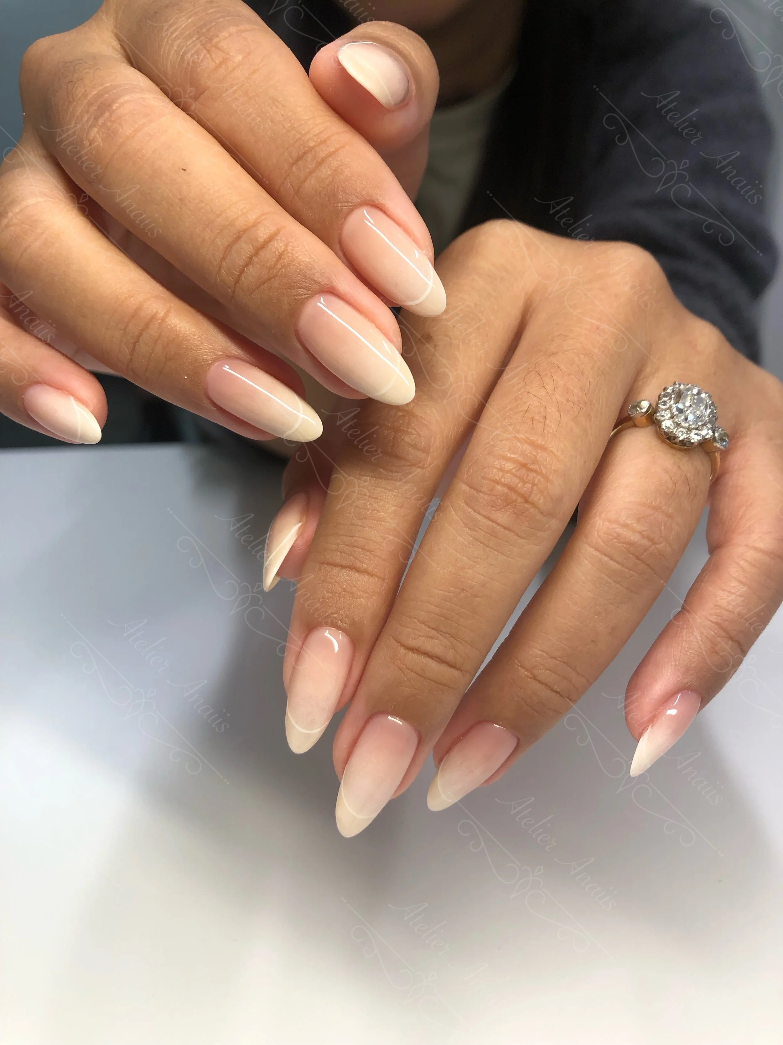 Long nails featuring translucent French tip nail art on milky white ombre base for weddings.