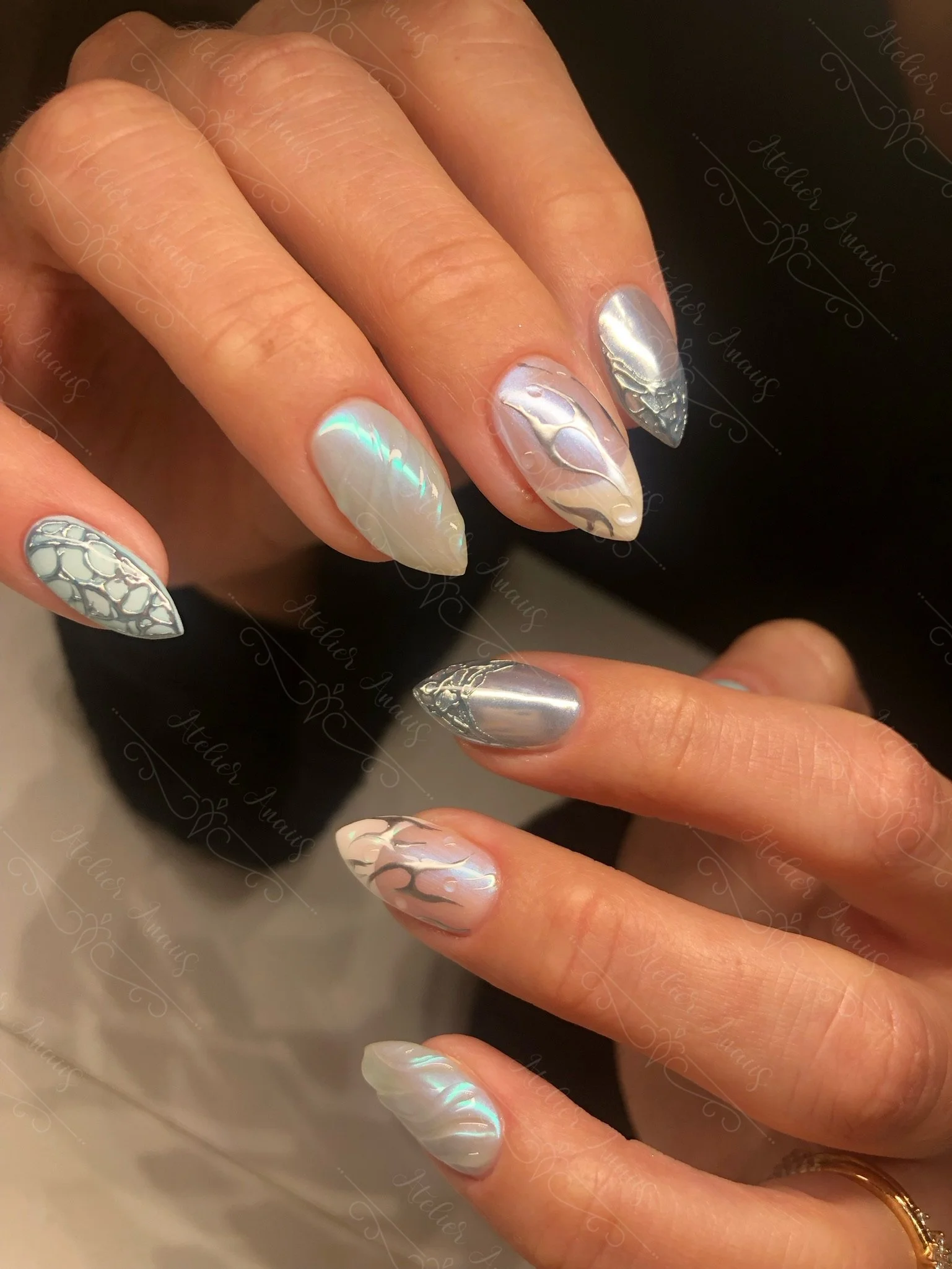 Long nails with abstract silver nail art with white French tips on chrome base. 