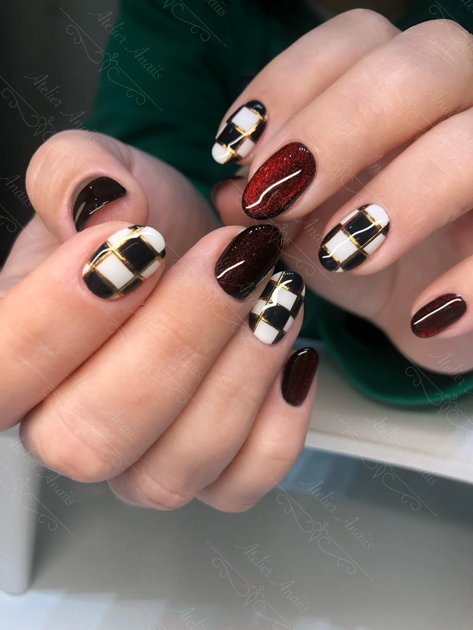 Medium length nails with Ferrari red cat-eye velvet gel polish with white and black checkerboard pattern. 