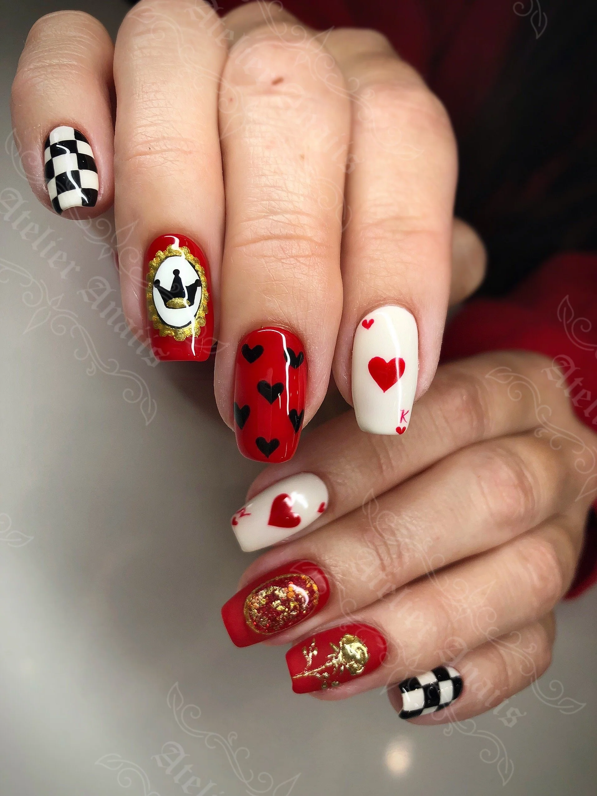 Alice in Wonderland-inspired long nails with hearts, playing cards, and checkerboard pattern nail art for Valentine’s Day.