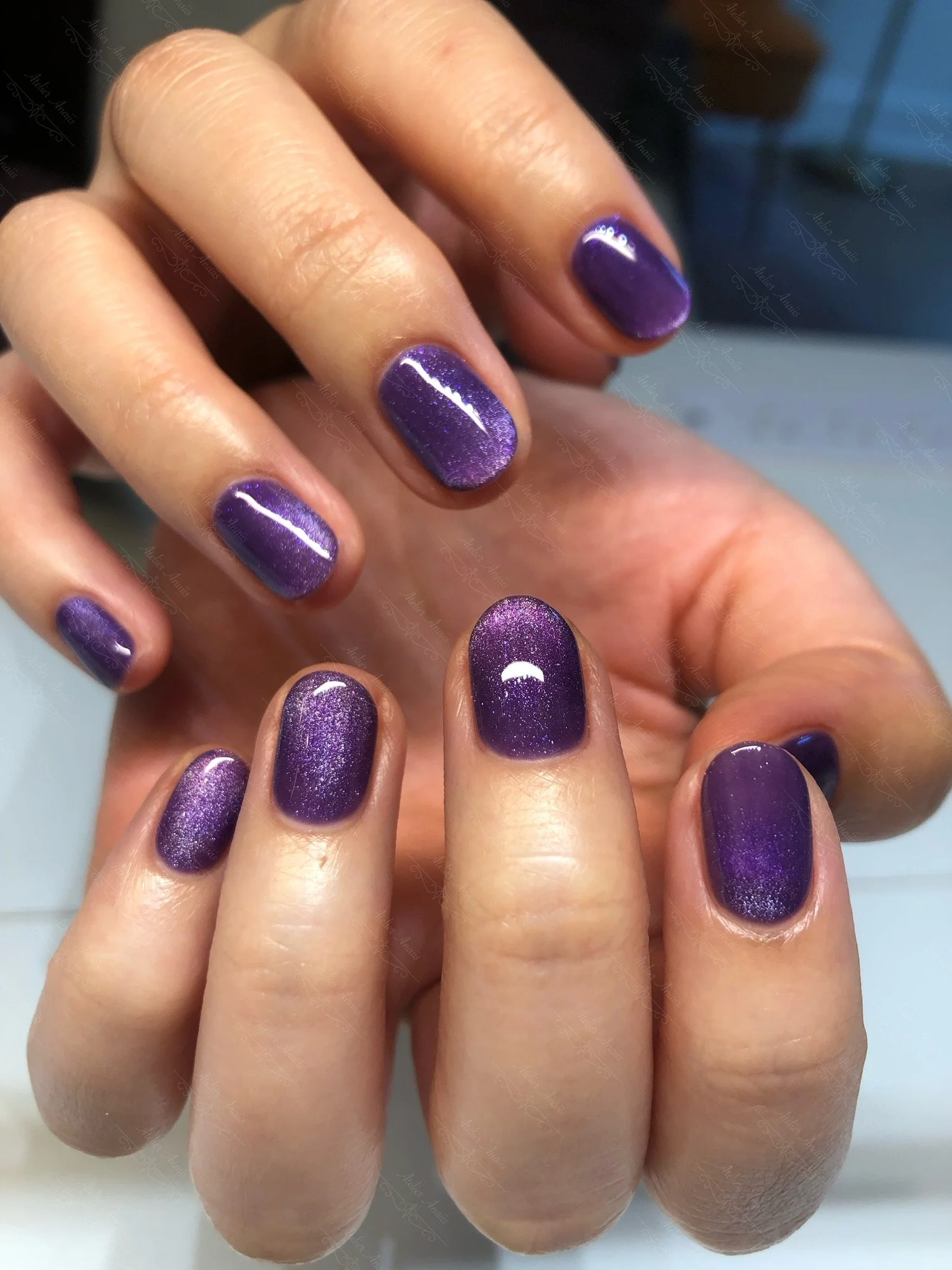 Short nails featuring a bright purple cat-eye velvet gel polish.