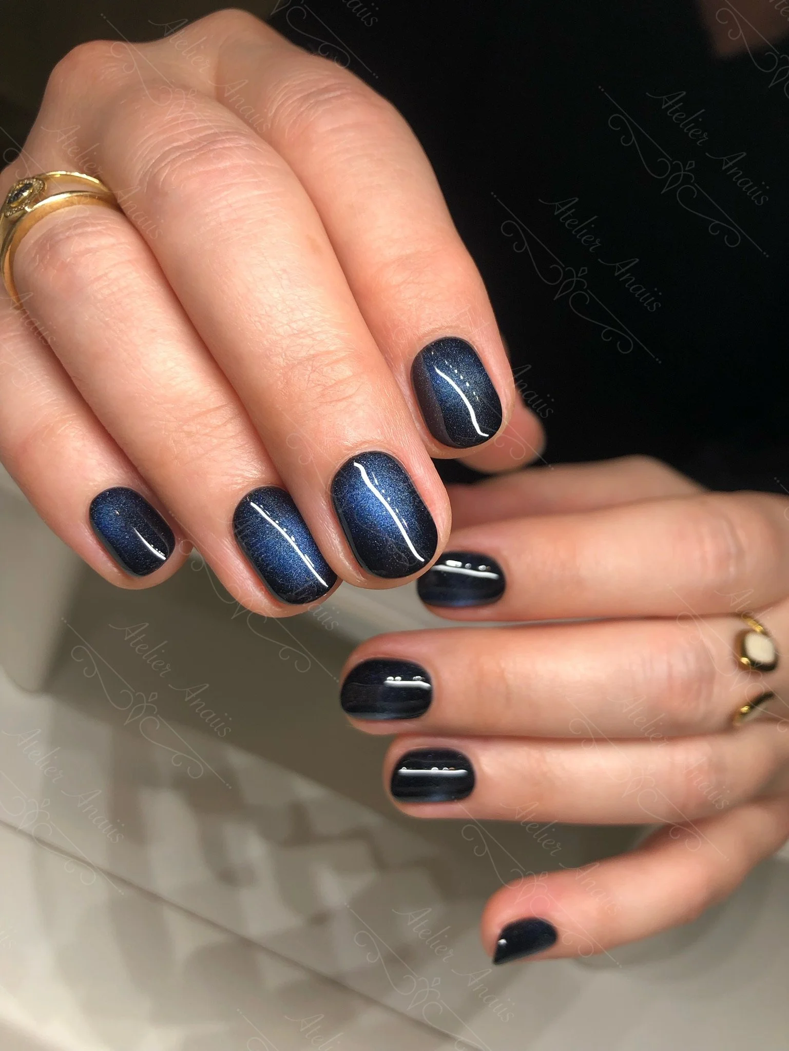 Short nails featuring a deep ocean blue cat-eye velvet gel polish.
