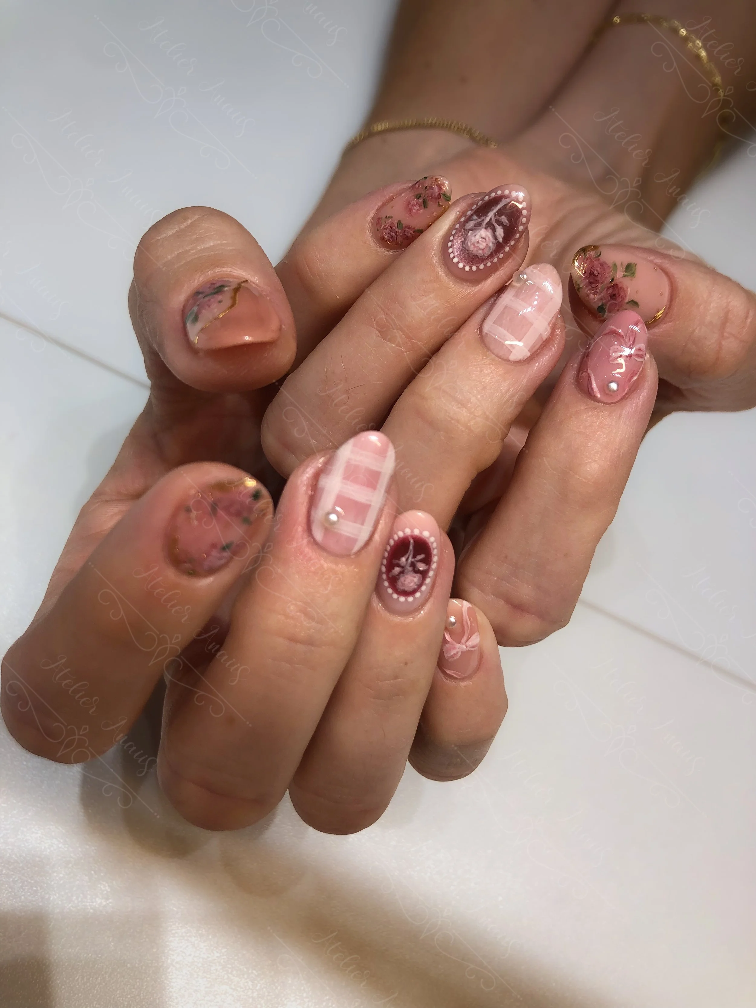 Hands with medium nails featuring subdued classy pink nail art with pearls