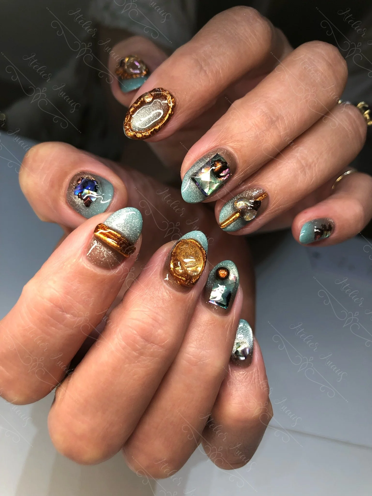 Medium nails with embossed brass detailing in earth colors and turquoise. 