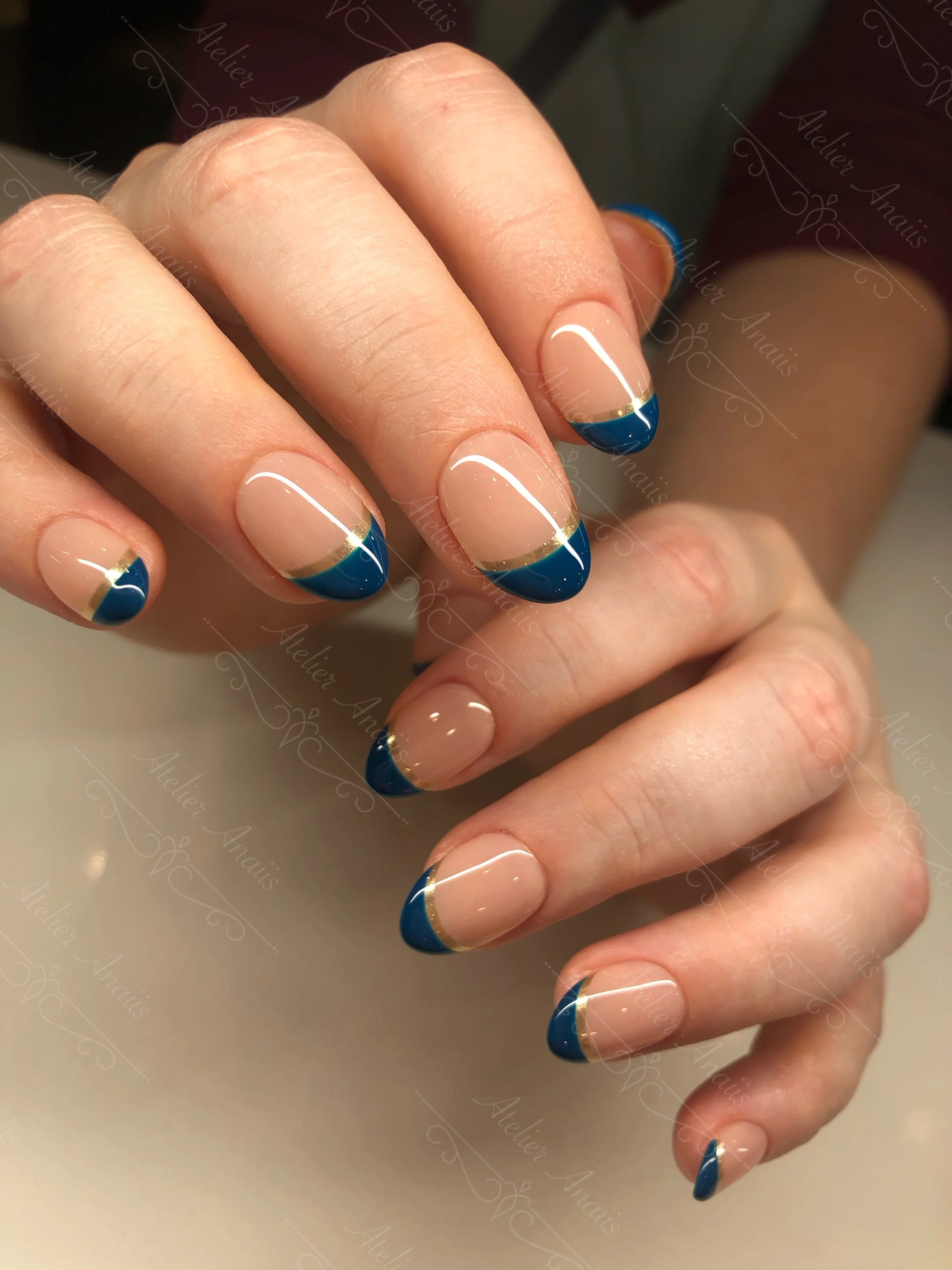 Medium nails with champagne gold and blue double French tip nail art on glossy nude base for weddings. 