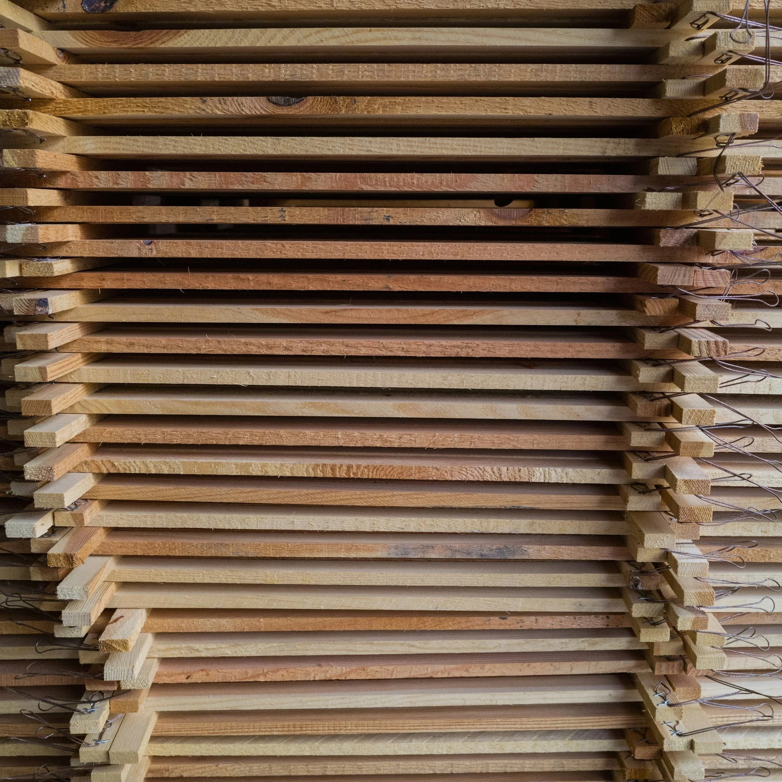 Wood boards stacked on top of each other. Cover image of the Atelier Anaiis blog post, "Thicker Natural Nails vs. Stronger Nails: What Actually Works".