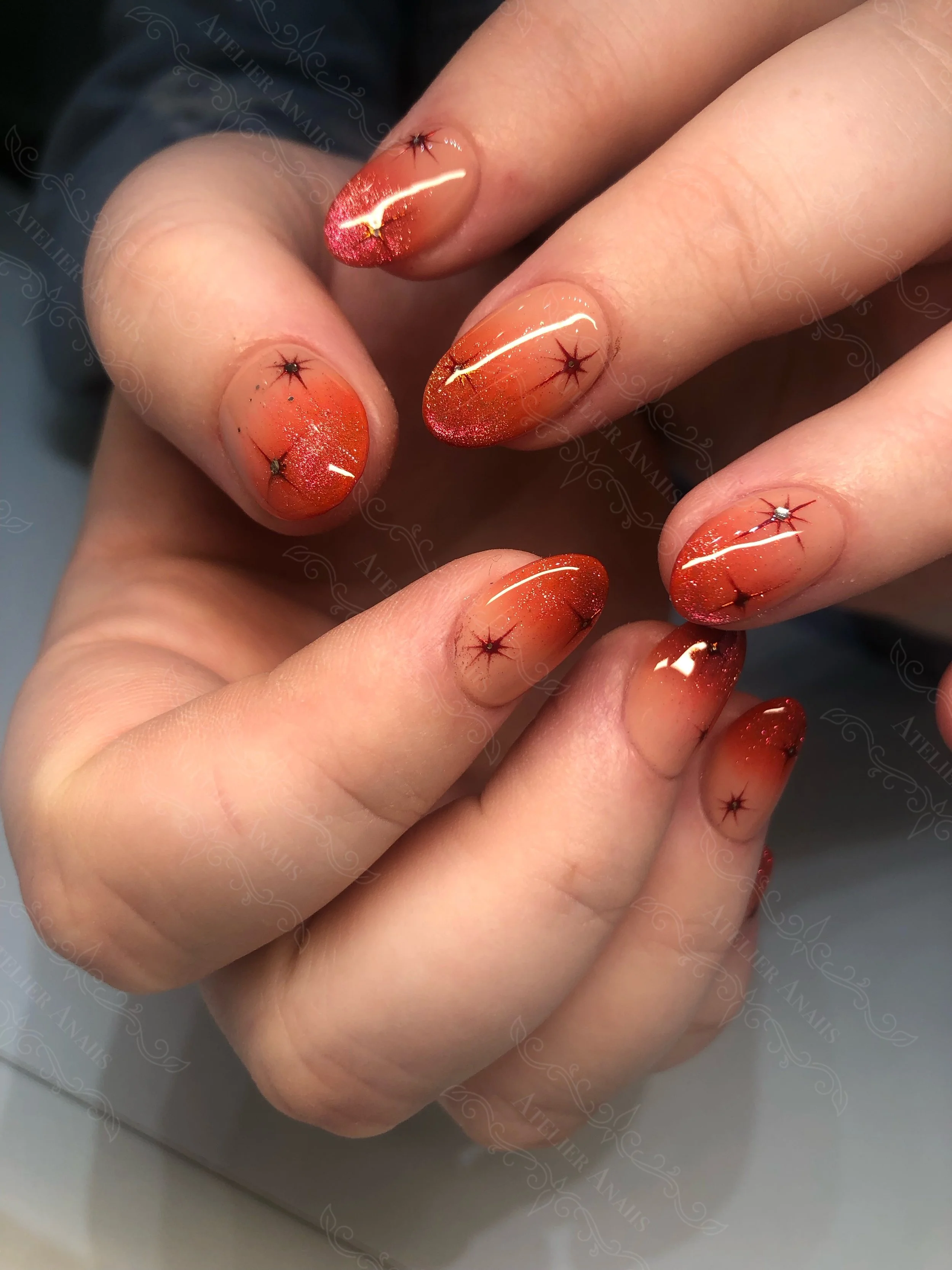Celestial nails featuring stars and orange ombre nail art at a nail salon in Philadelphia.