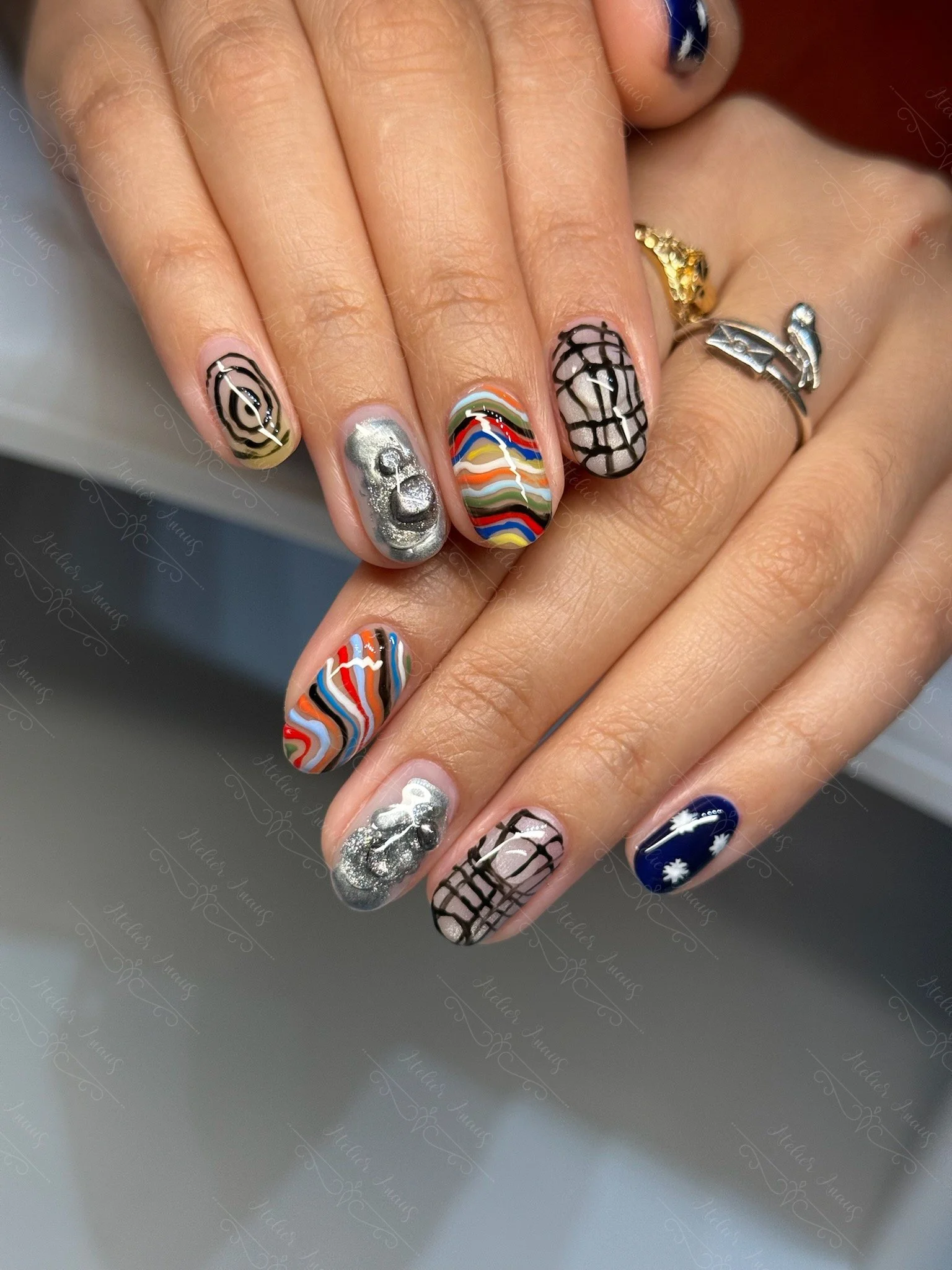 Fun abstract nail art in black, silver, and rainbows at a nail salon in Old City.