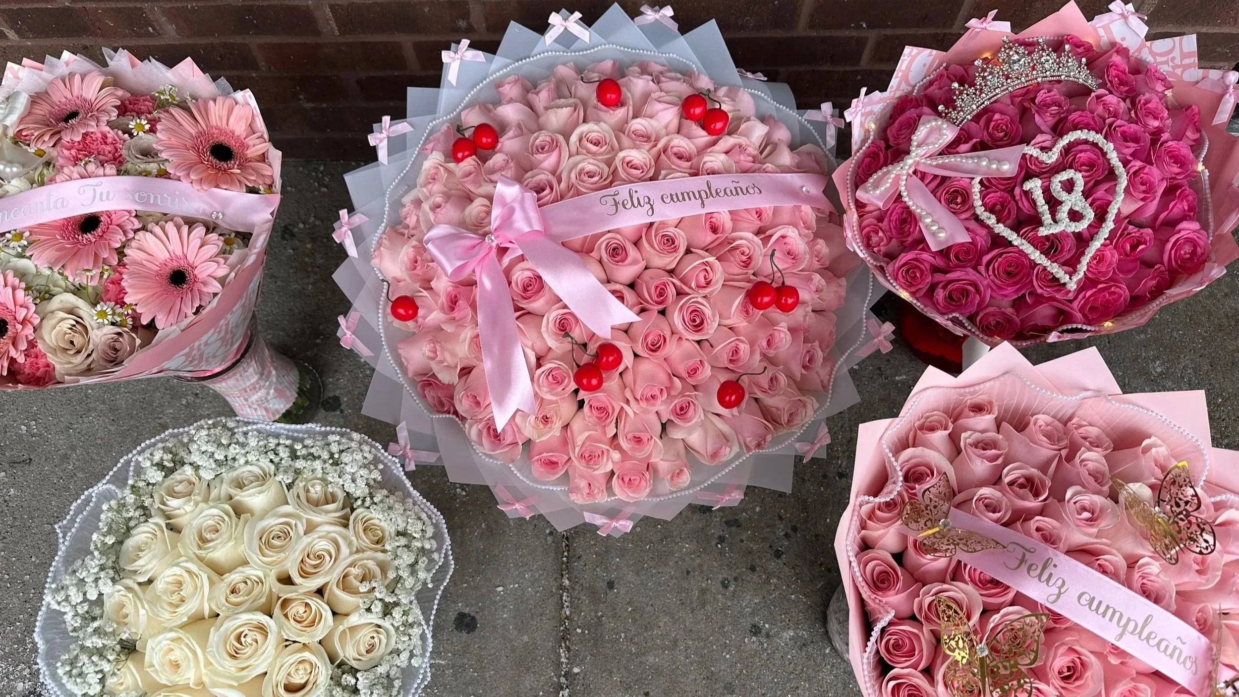Offers a collection of six bouquets of pink and white roses, accented with ribbons, pearls, and decorative items, with birthday messages in Spanish.