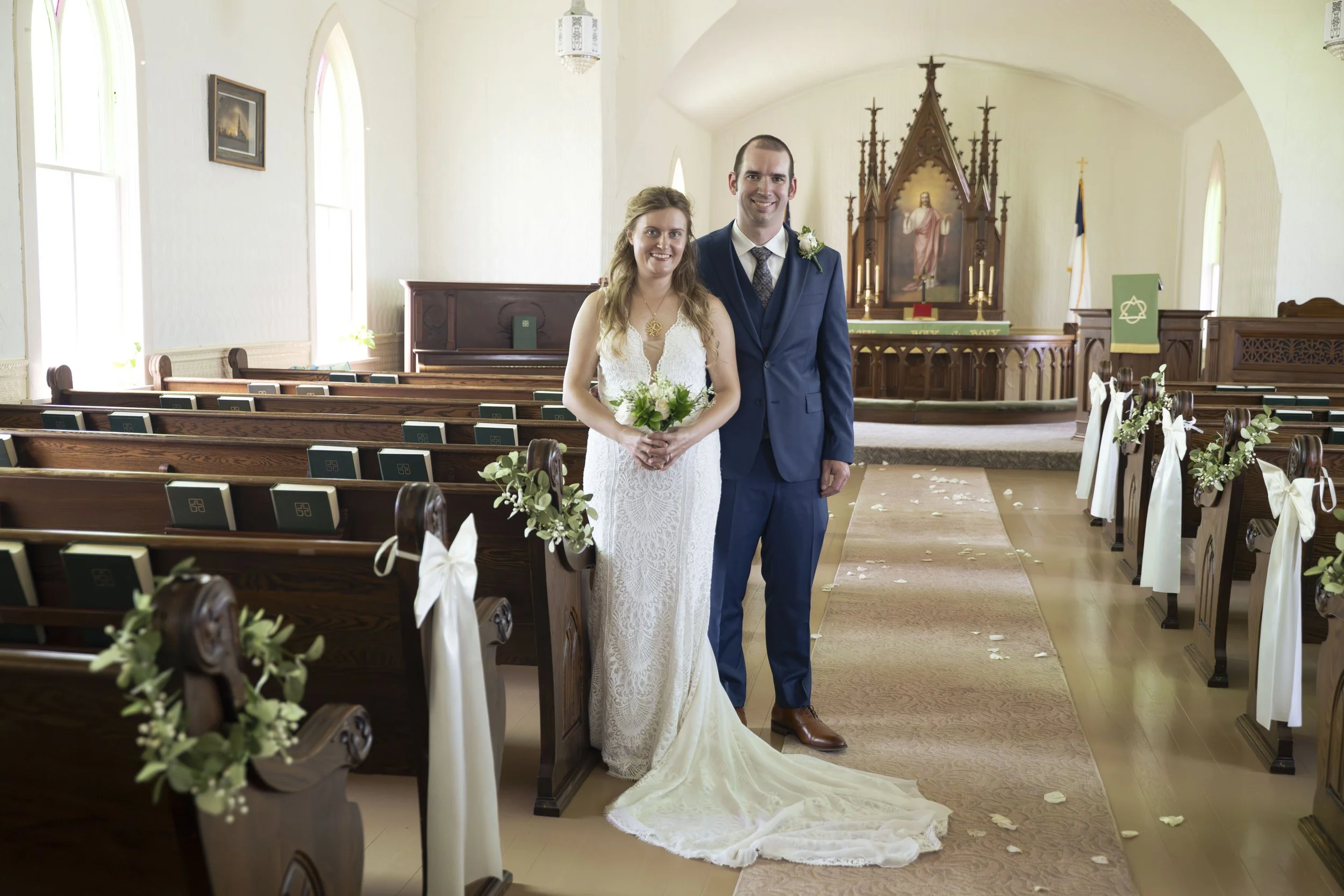 A bride and groom standing inside Tunbridge Lutheran Church on their wedding day.