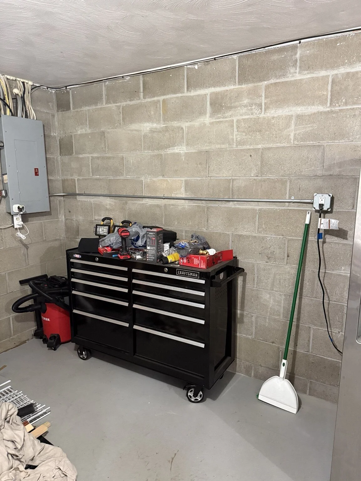 After: New garage GFCI receptacle circuit installed in surface-mounted metal conduit from the electrical panel.