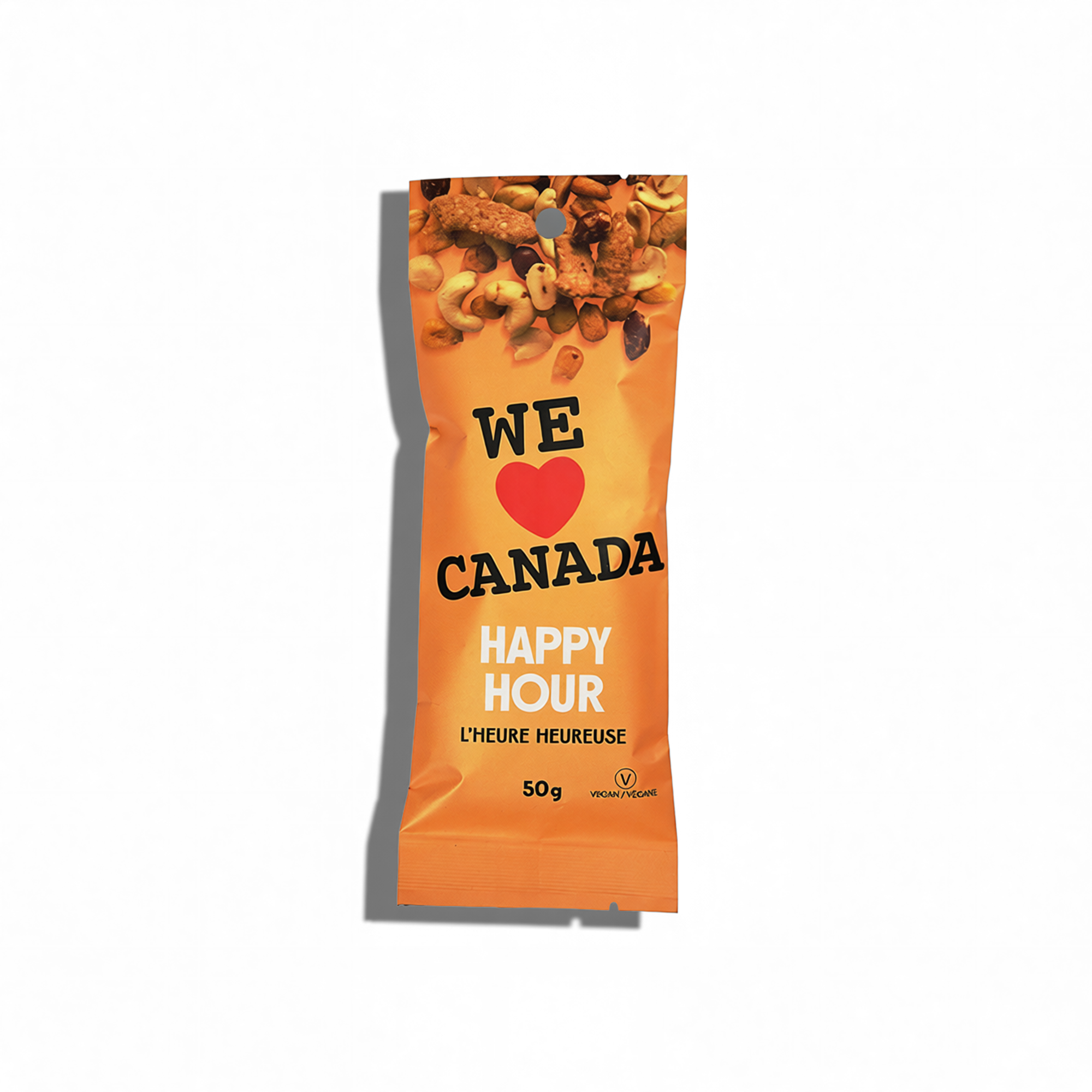 Packaged vegan snack with mixed nuts, dried fruits, and seeds, labeled 'We Love Canada Happy Hour' with a heart symbol, indicating a Canadian theme and a 50-gram weight.
