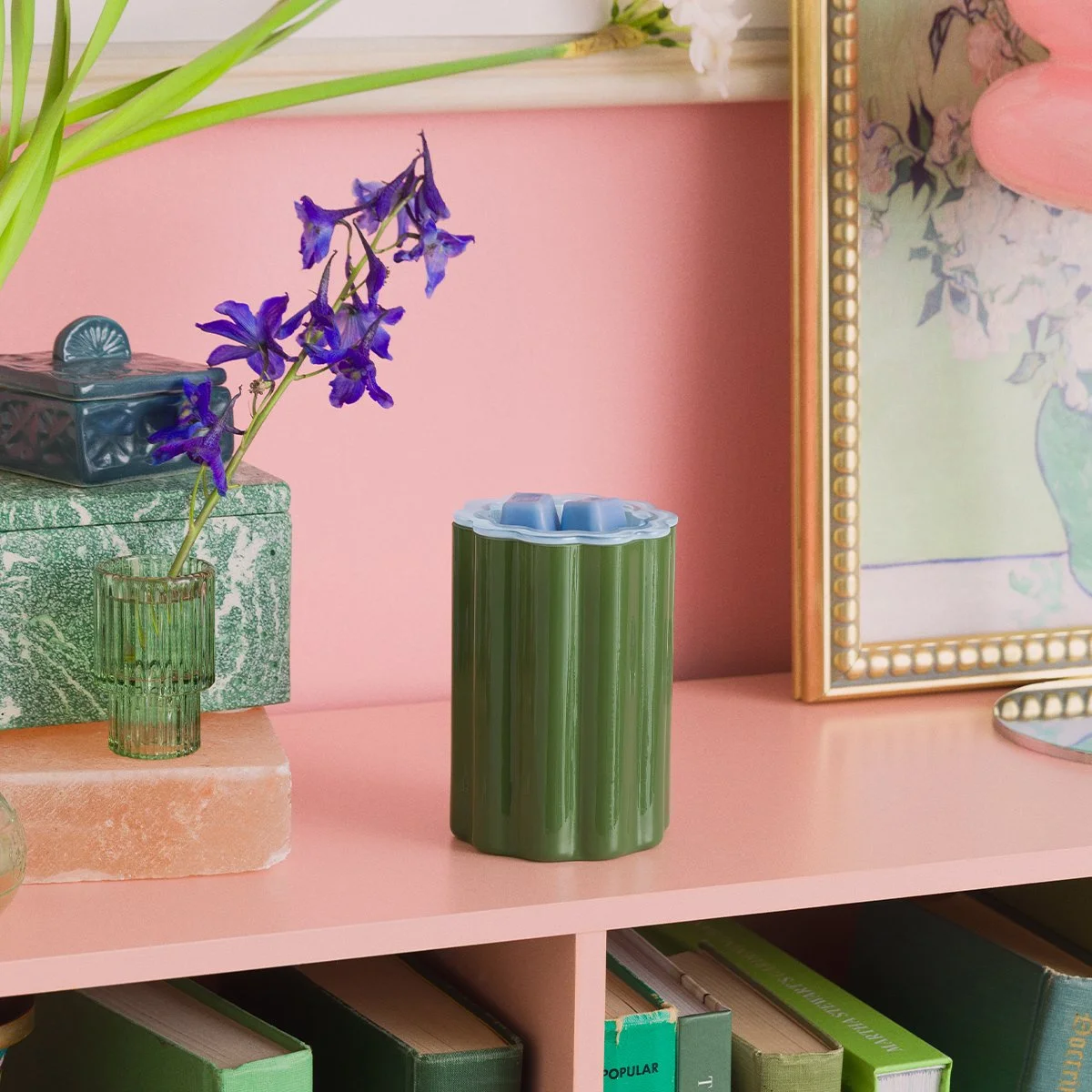 Green Bloomie wax warmer illuminated to showcase its vibrant colour and playful, artistic design.