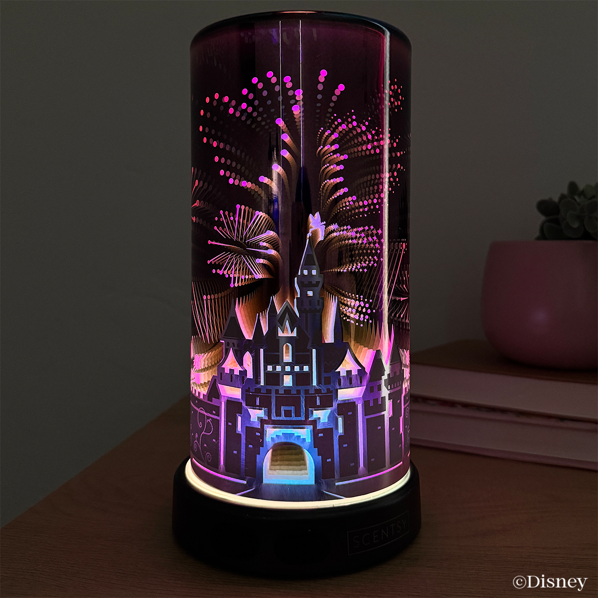 Front view of the Sleeping Beauty Castle Scentsy Diffuser glowing with colourful fireworks lighting, celebrating the 70th anniversary of Disneyland Resort.